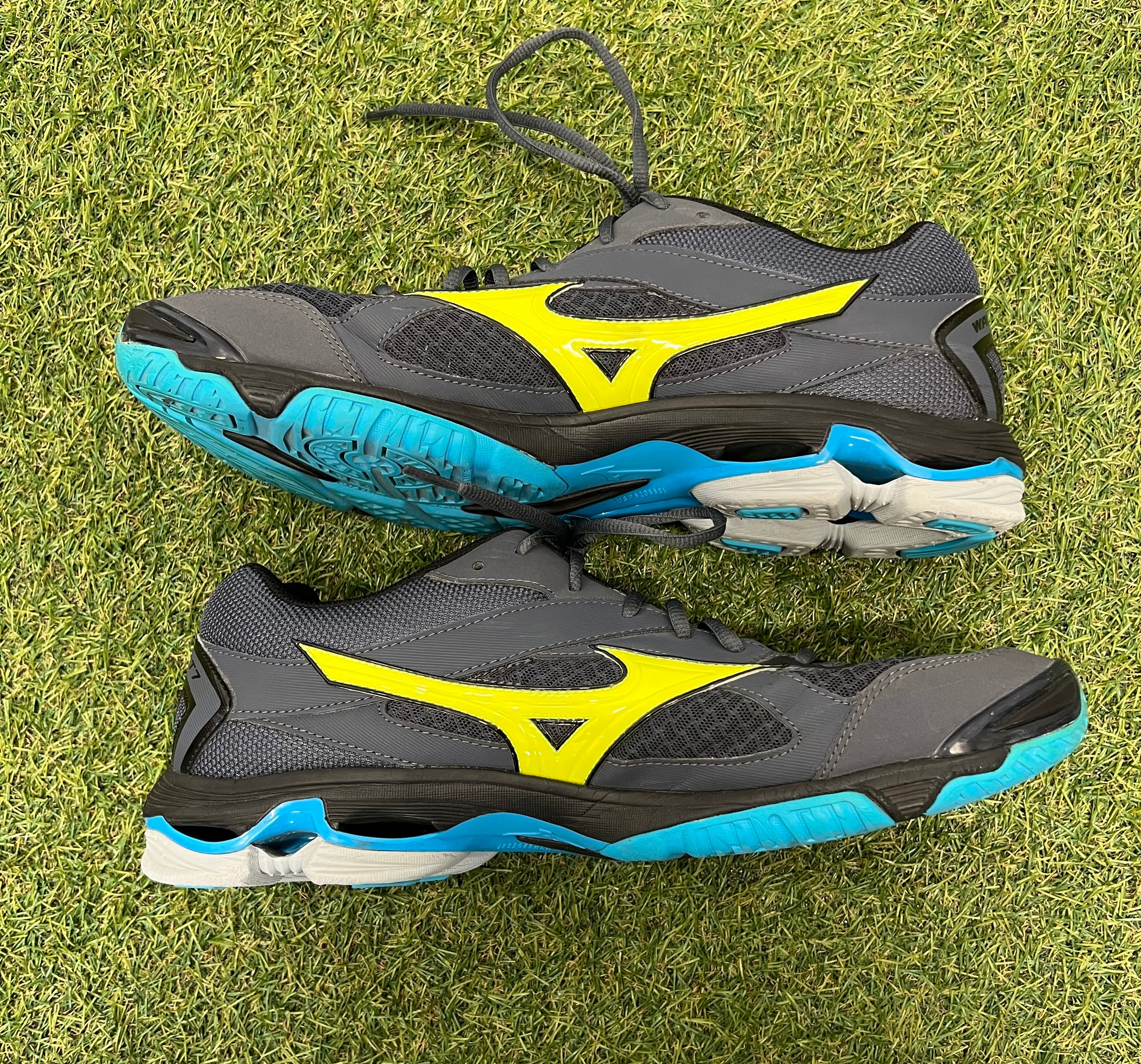 Side profile of Mizuno Wave Bolt 7 trainers displaying grey and yellow design with blue sole cushioning
