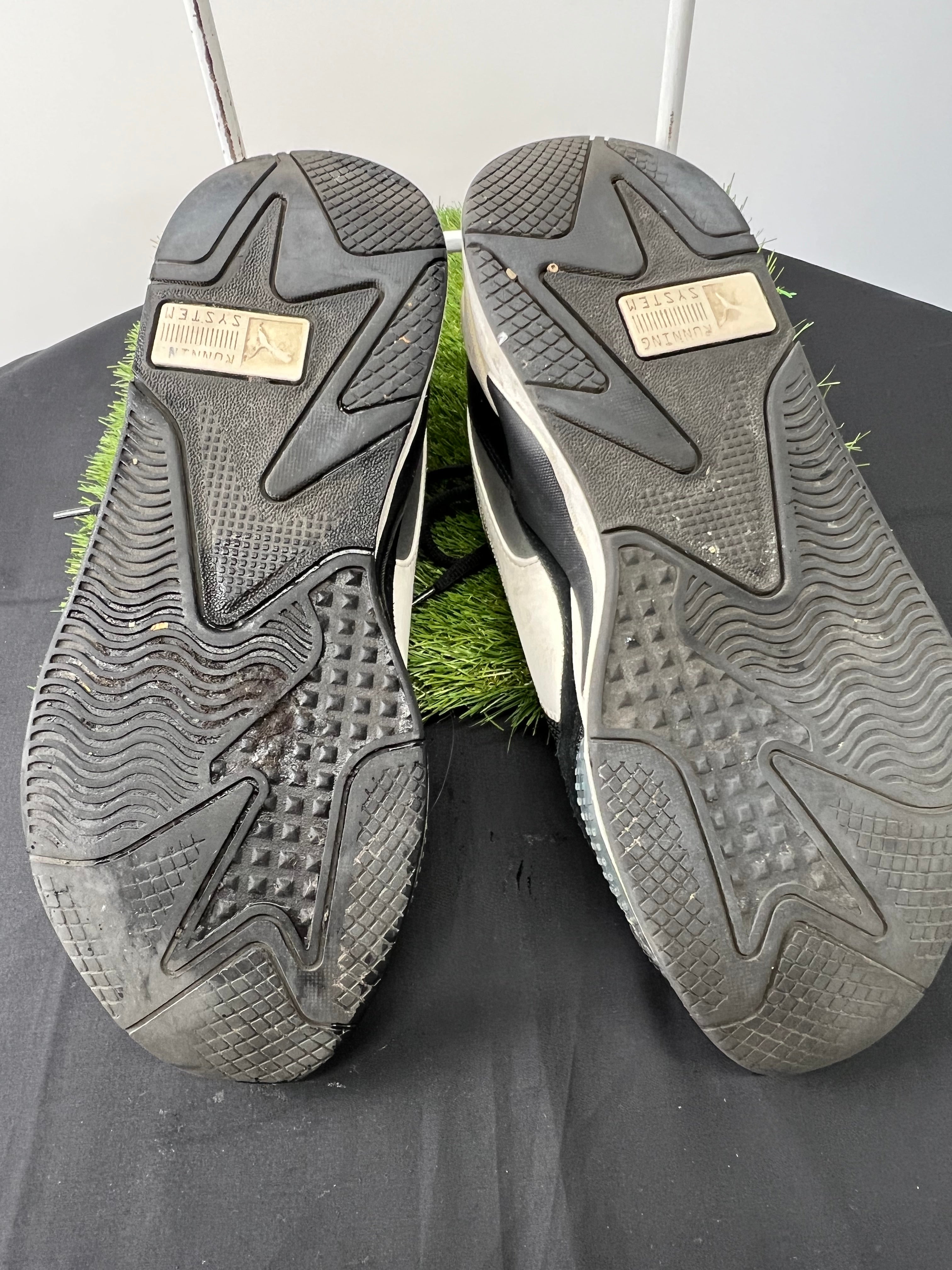 Soles of Puma RS-X trainers showing rubber grip and Puma Running System logo