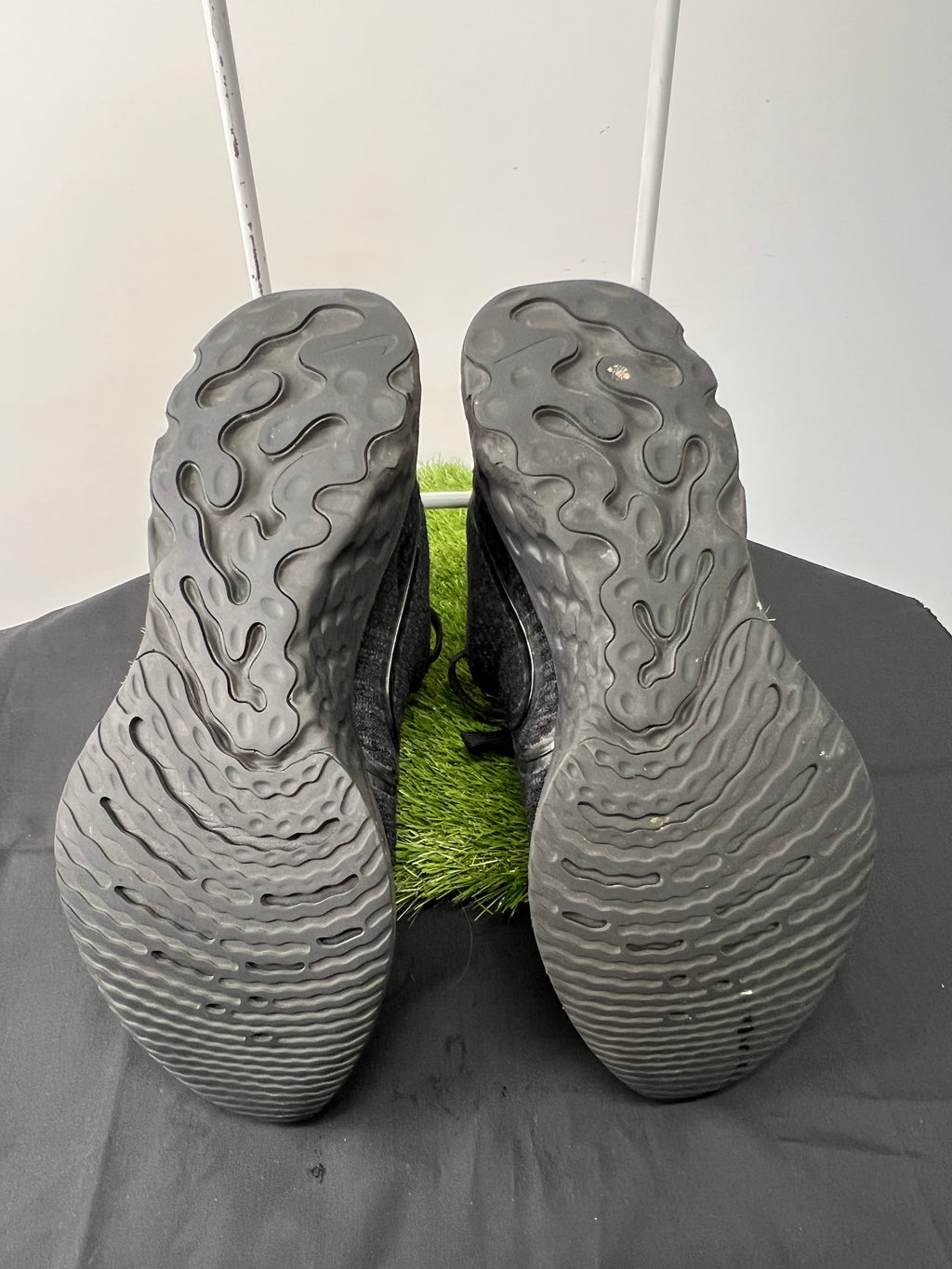 Soles of black Nike React trainers showing textured grip pattern
