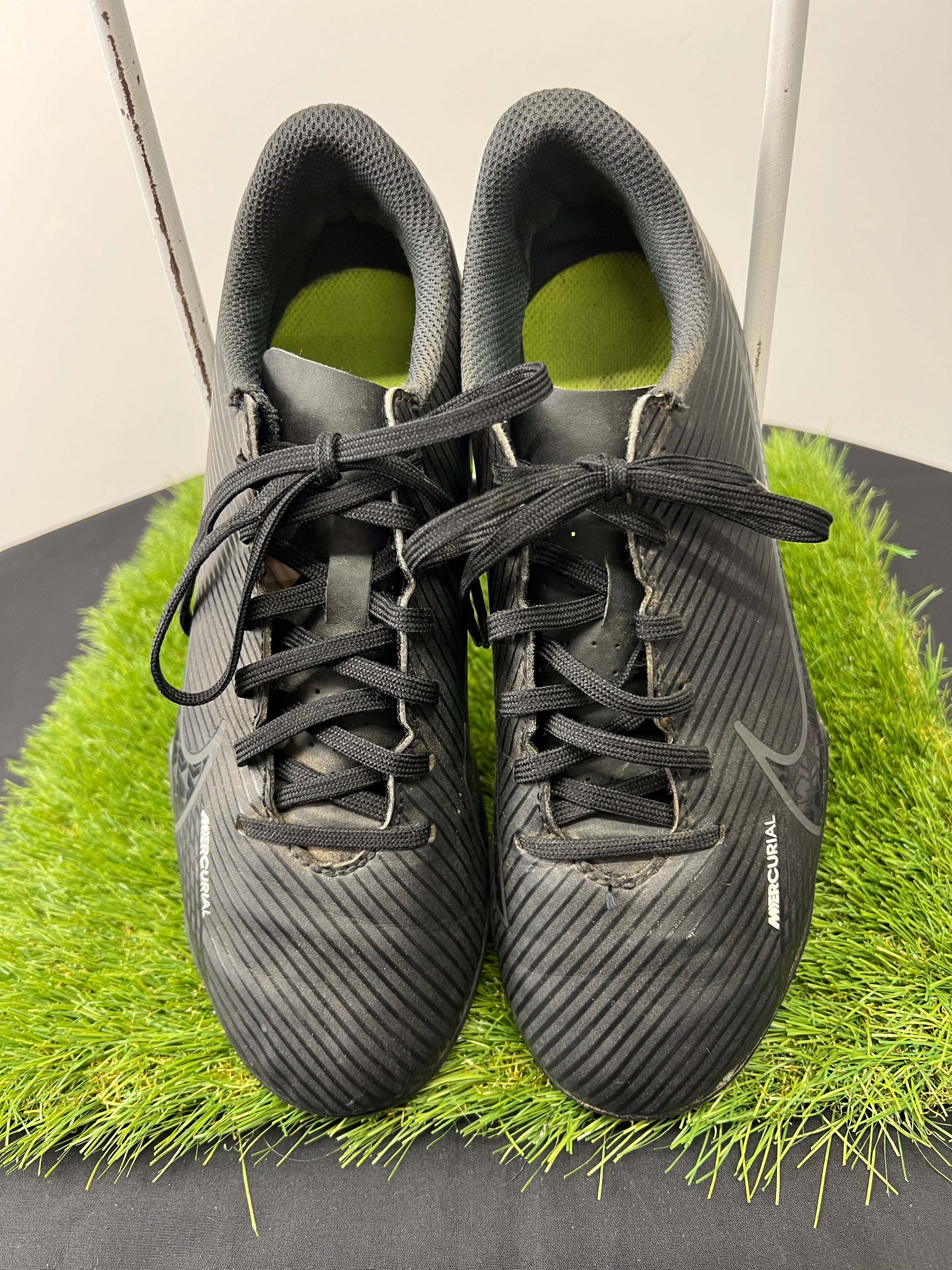 Top view of kids black Nike Mercurial football boots showing black laces and textured upper