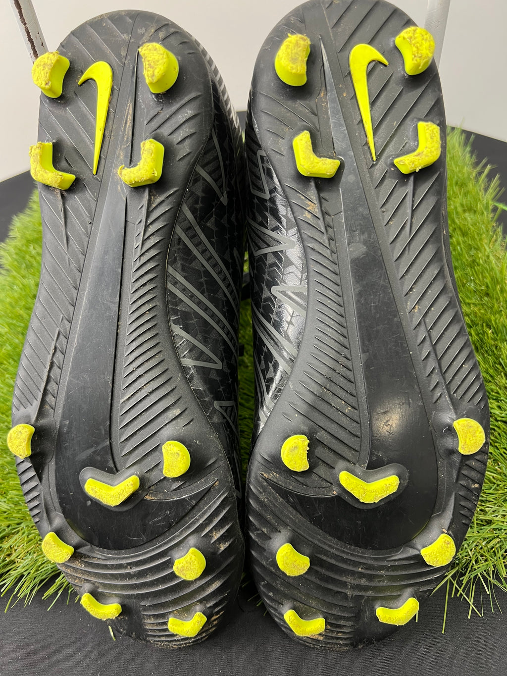 Close-up of the sole of black Nike Mercurial football boots with bright yellow studs