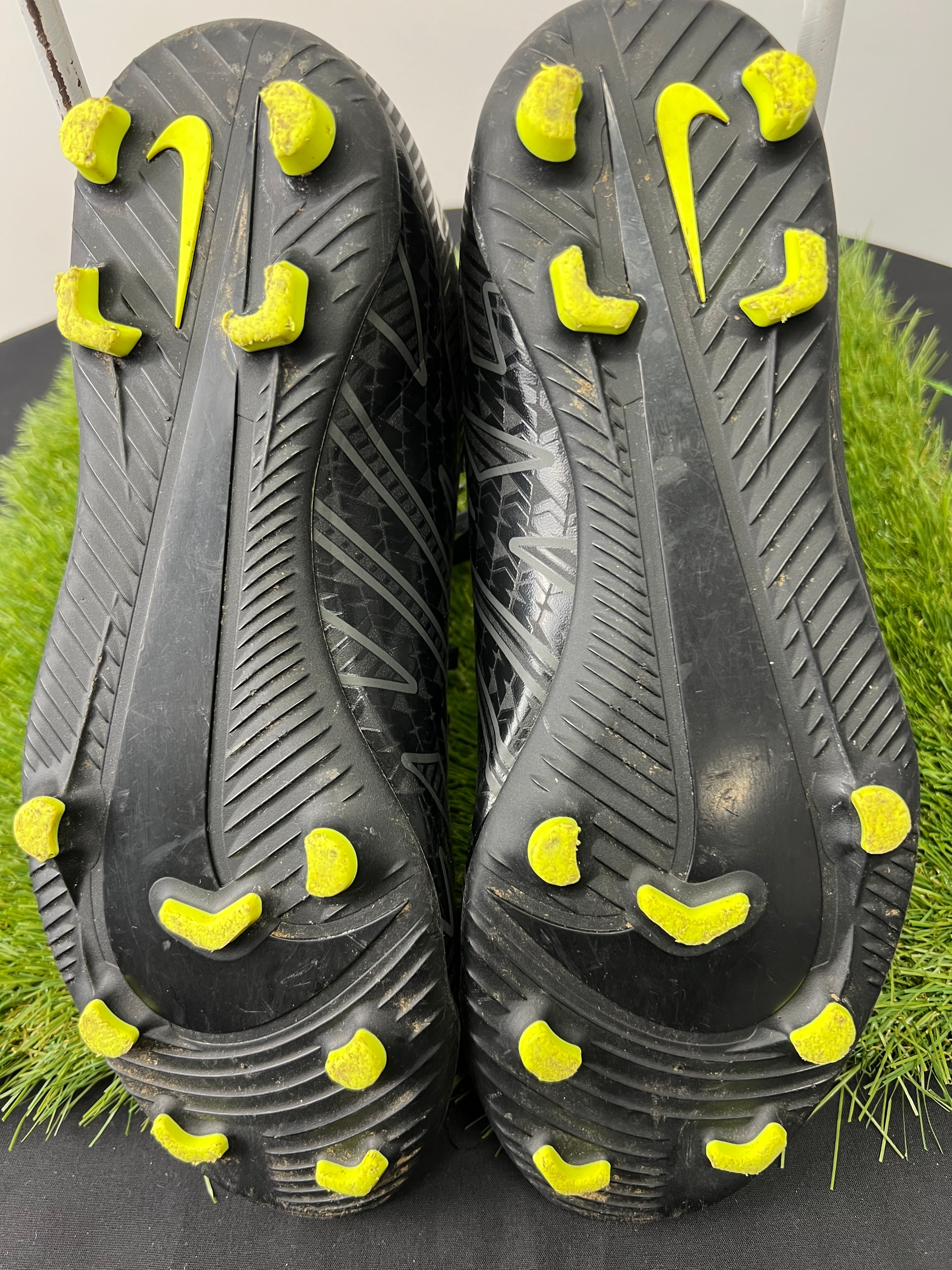 Close-up of the sole of black Nike Mercurial football boots with bright yellow studs