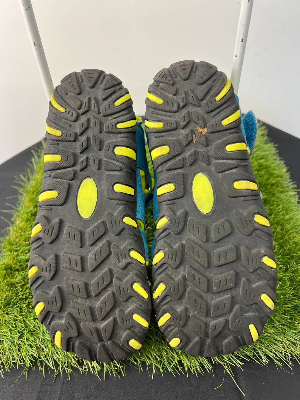 Soles of children's water sandals showing black rubber with yellow grip accents