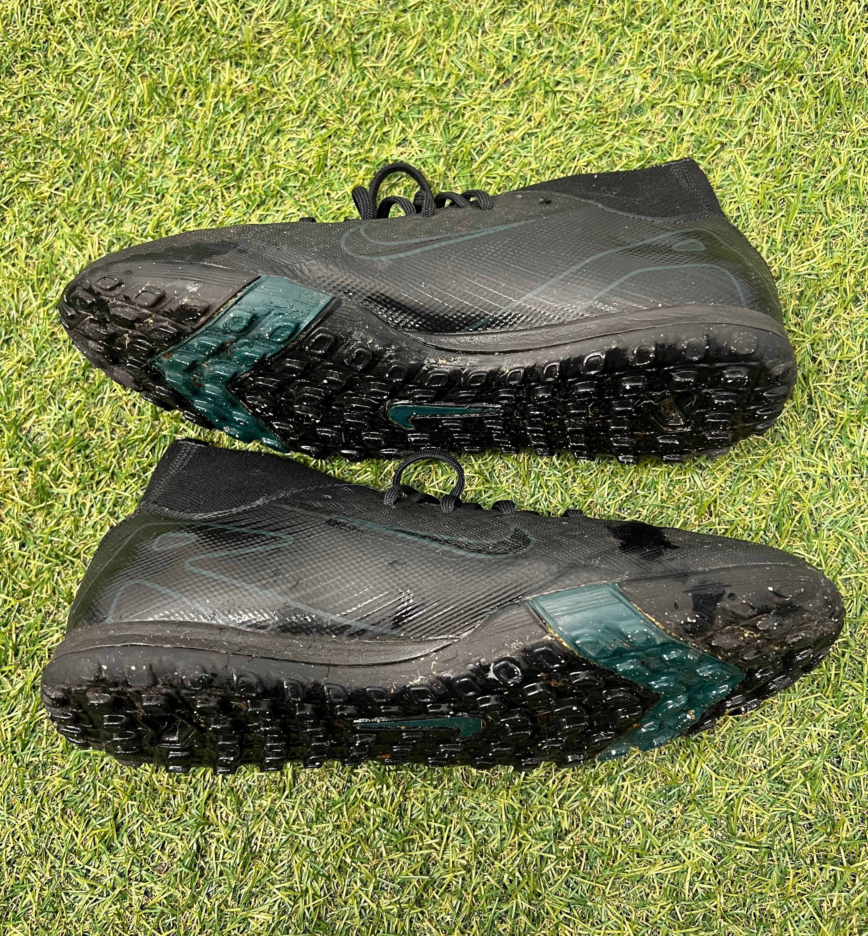 Side view of black Nike Astro Turf football boots showcasing textured upper and sole tread