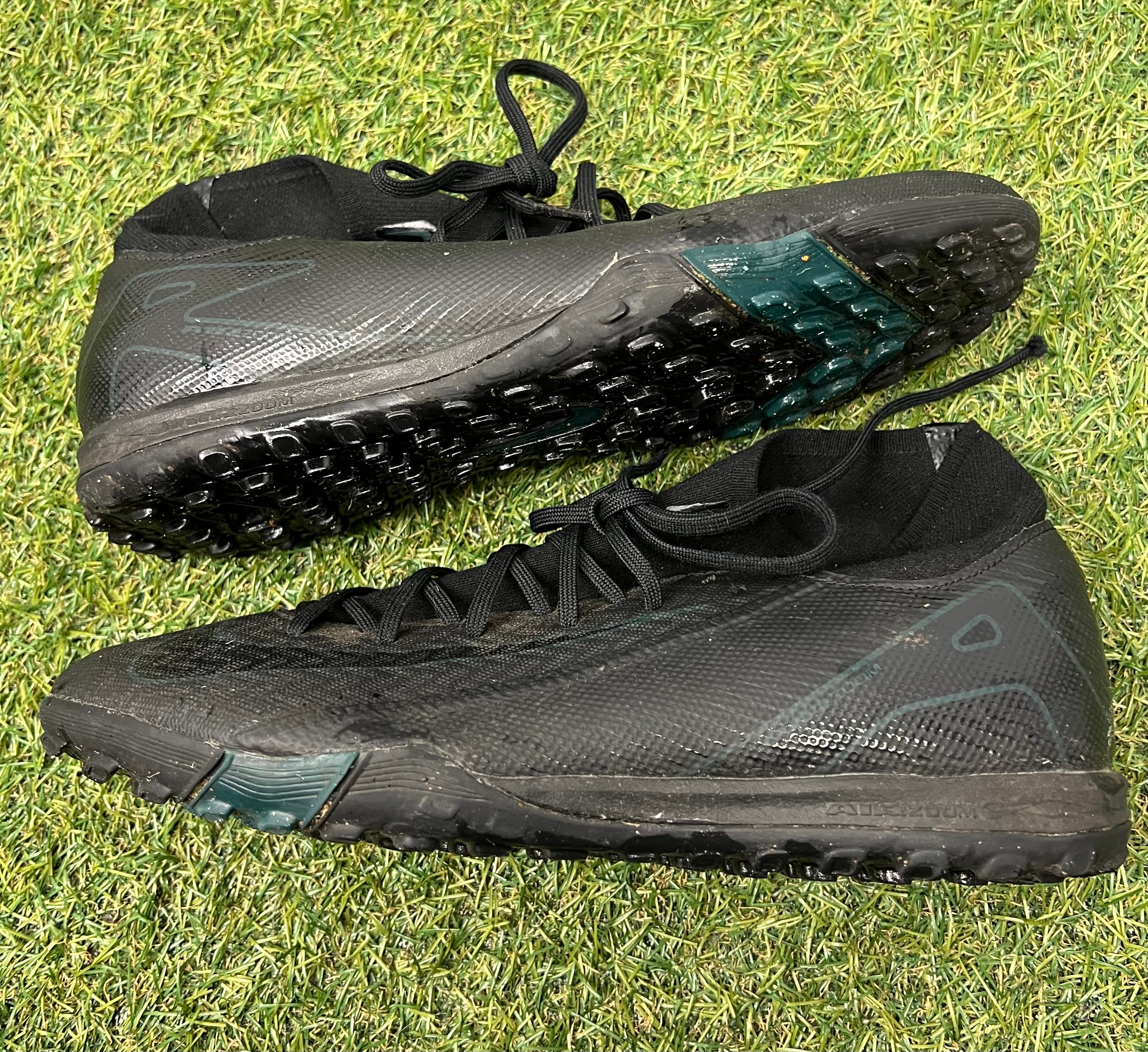 Alternate side view of Nike Astro Turf football boots on artificial grass background