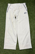 Front view of white youth Slazenger cricket trousers with navy piping on pockets and drawstring waist