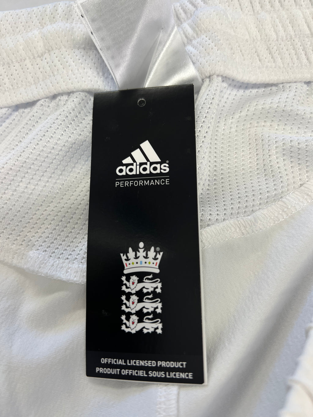 Close-up of Adidas and England cricket board logo on product tag inside waistband