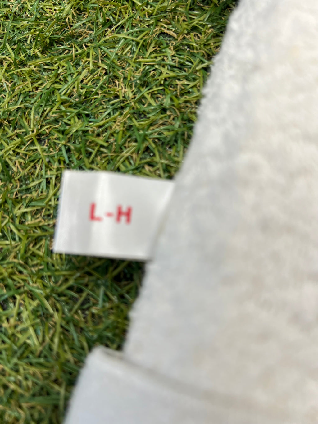 Close-up of the Men’s Shark Hammerhead thigh pad size tag labelled L-H attached to soft terry cloth lining