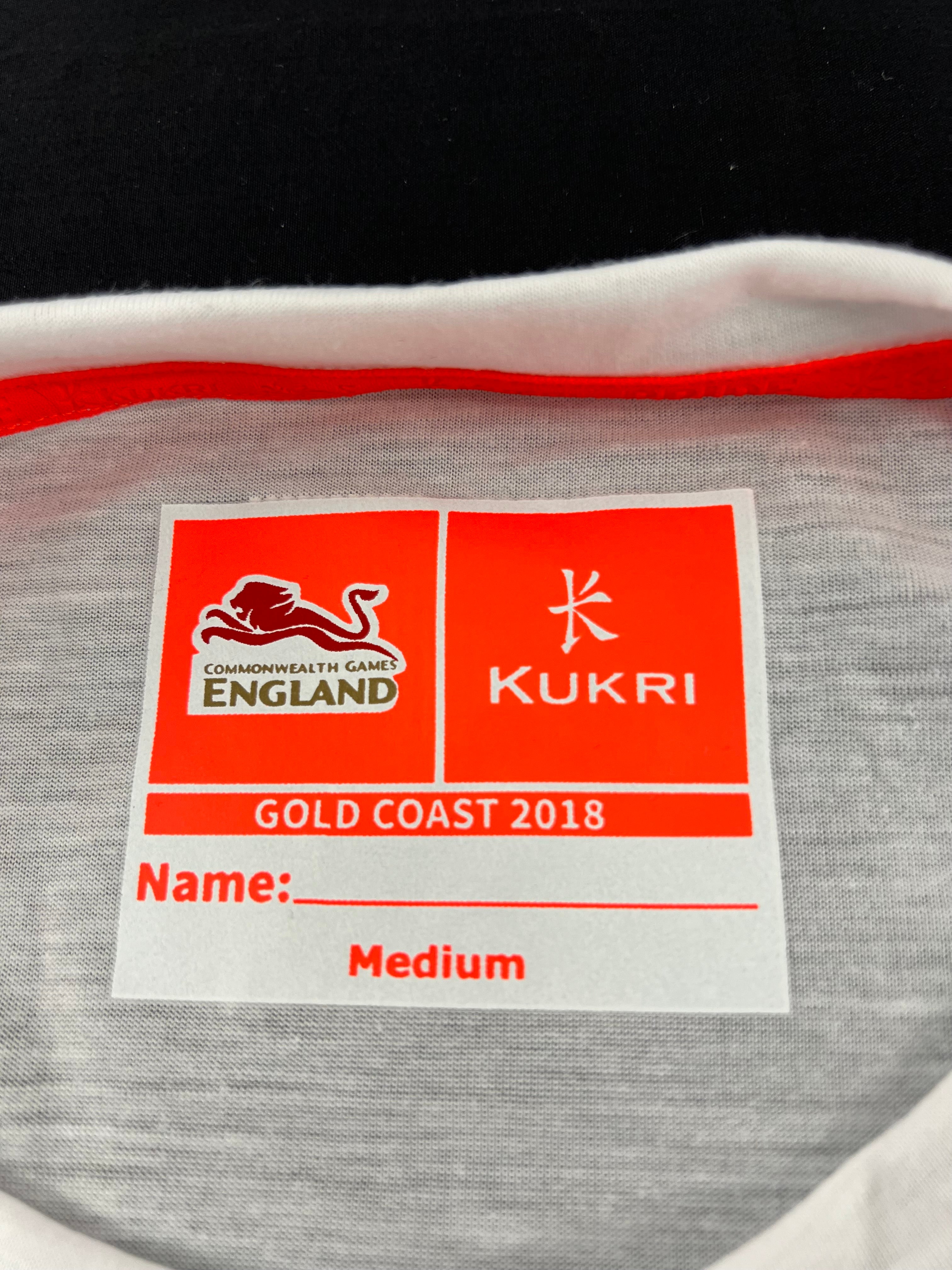 Inside collar label of shirt showing Kukri and Commonwealth Games England Gold Coast 2018 branding and size medium