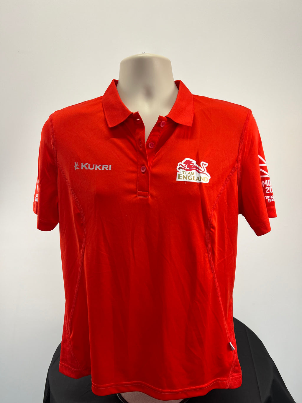 Front view of Kukri Team England women's red polo shirt with logo and button collar
