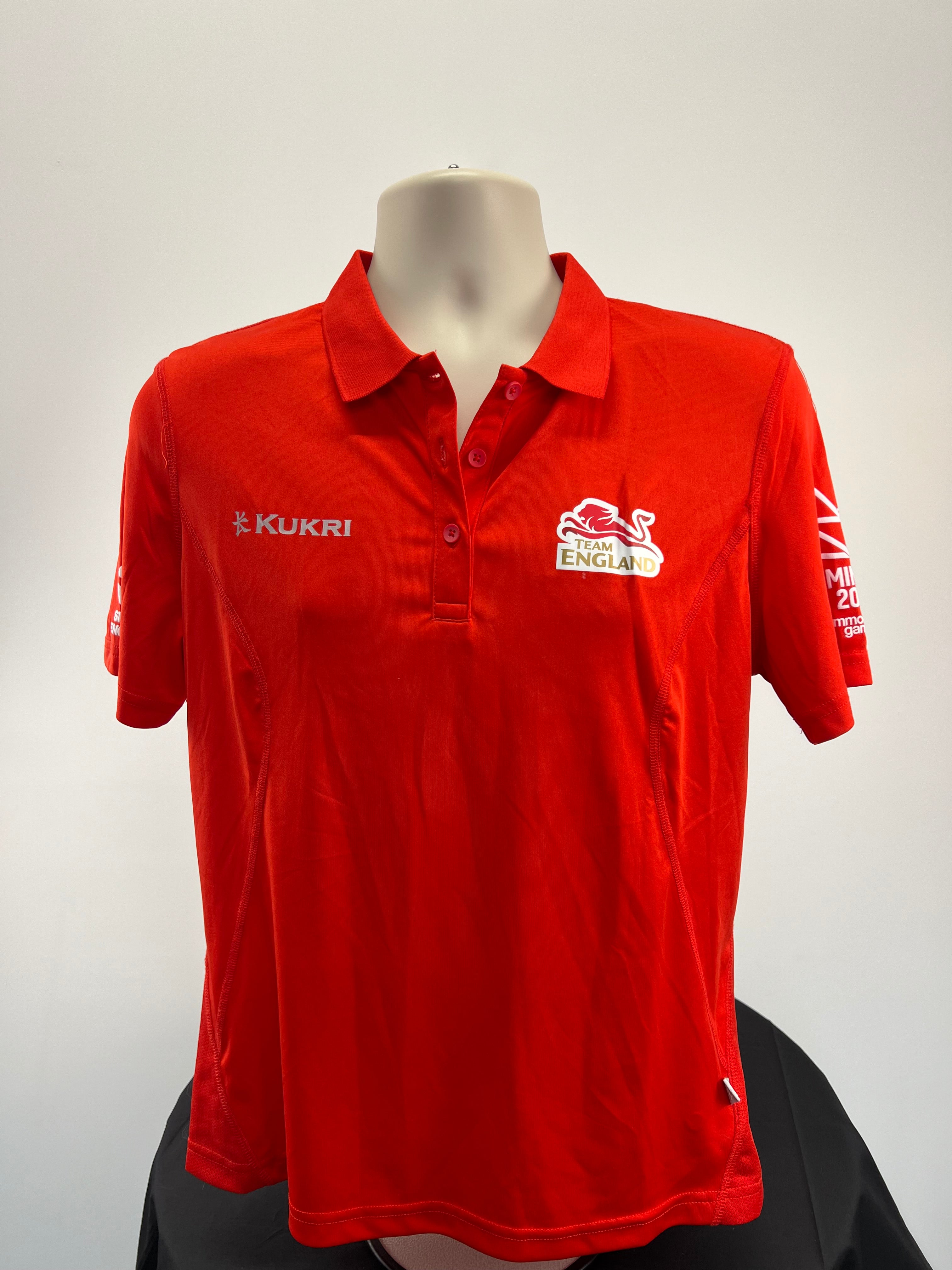 Front view of Kukri Team England women's red polo shirt with logo and button collar