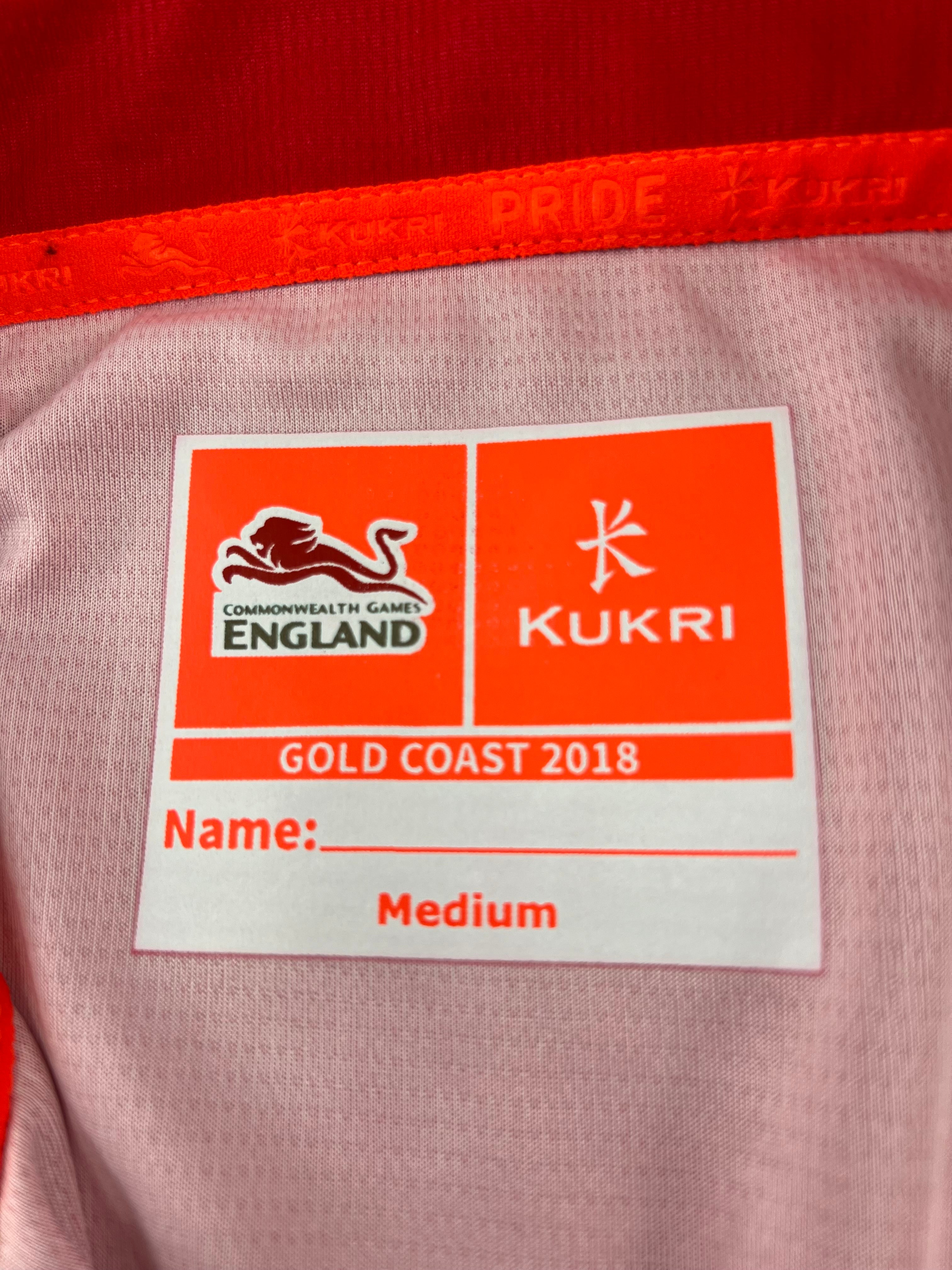 Inside label of Team England Commonwealth Games polo shirt with Kukri logo and size Medium