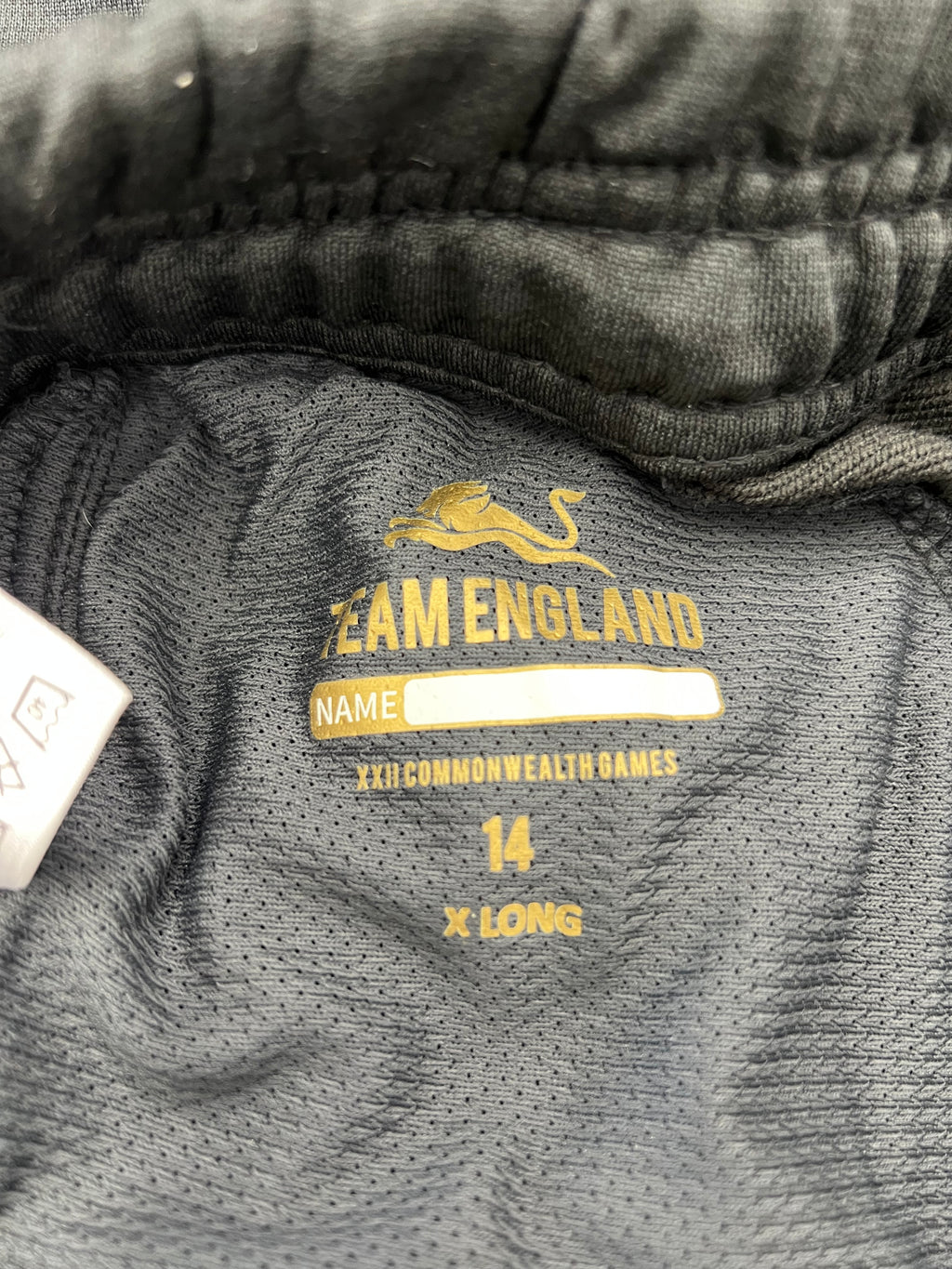 Inside label of Kukri Team England tracksuit bottoms showing size 14 XL and Commonwealth Games branding