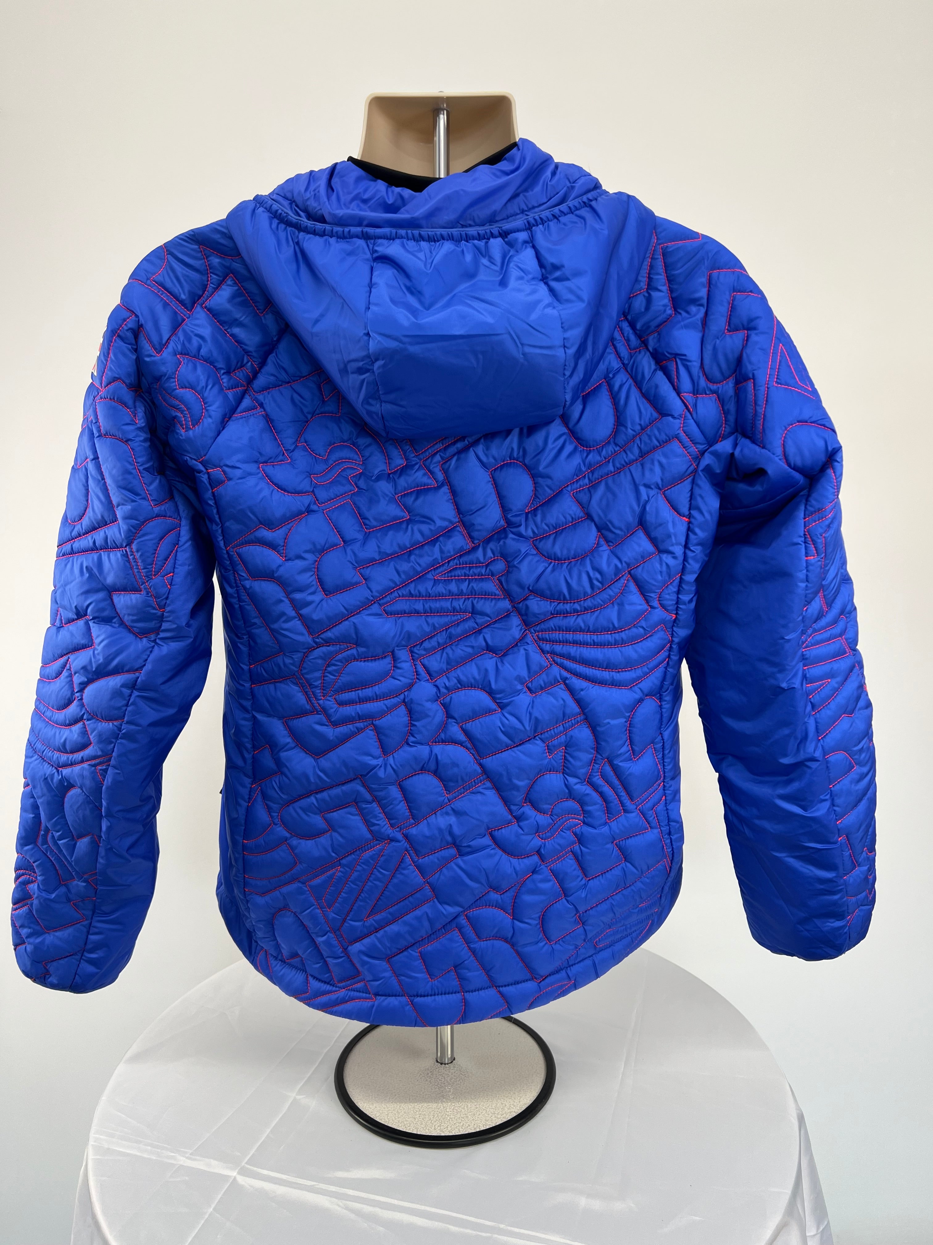 Back view of blue Team GB puffer jacket showing attached hood and continuous red quilting