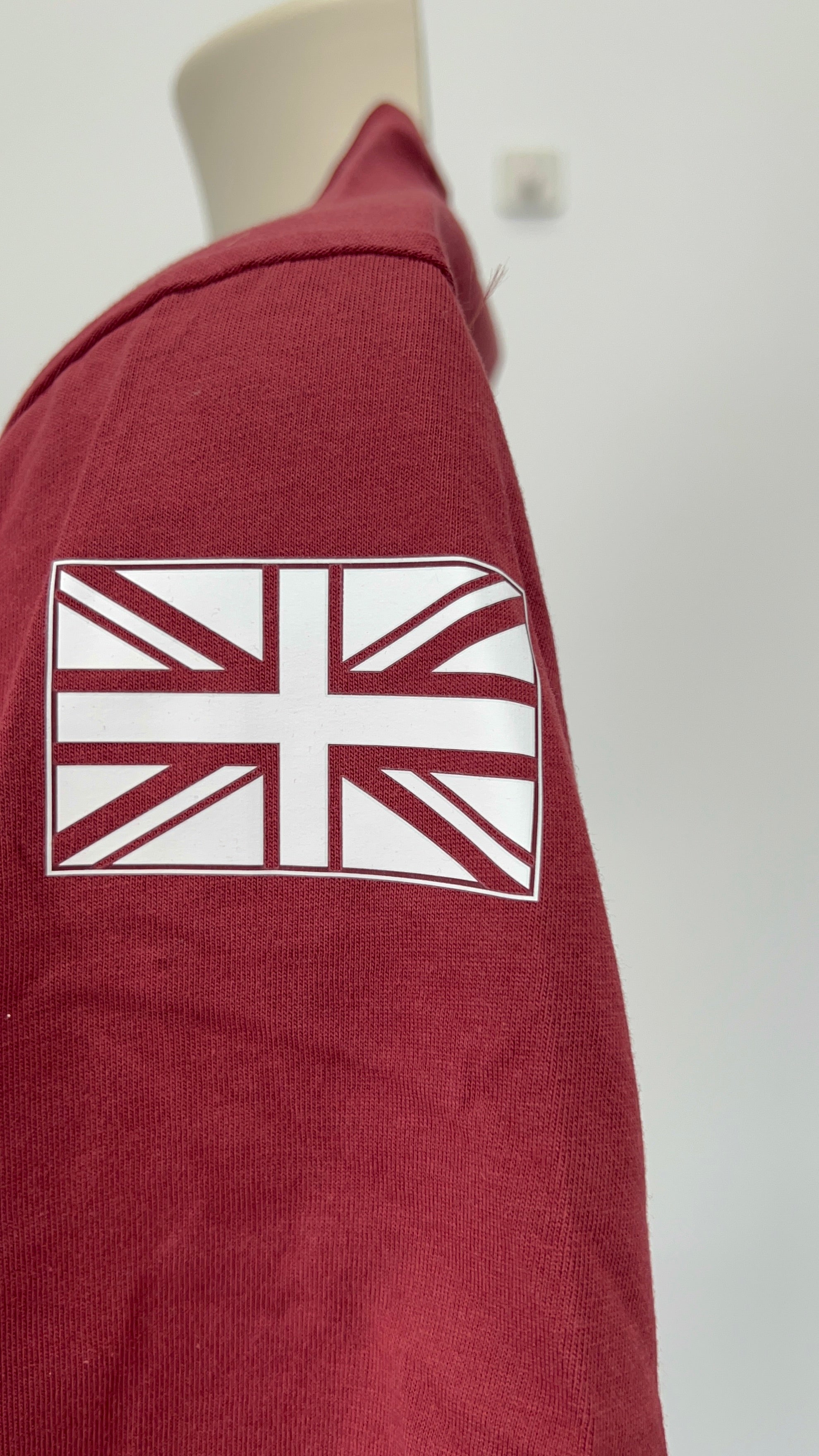 Close-up of Union Jack emblem printed on sleeve of burgundy Adidas Team GB t-shirt