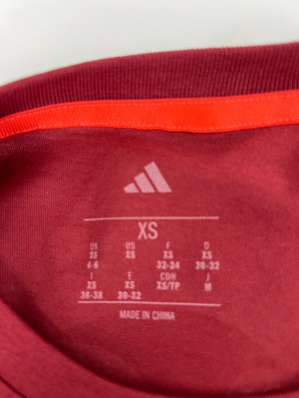 Inside neck label of Adidas Team GB t-shirt showing size XS and manufacturing details