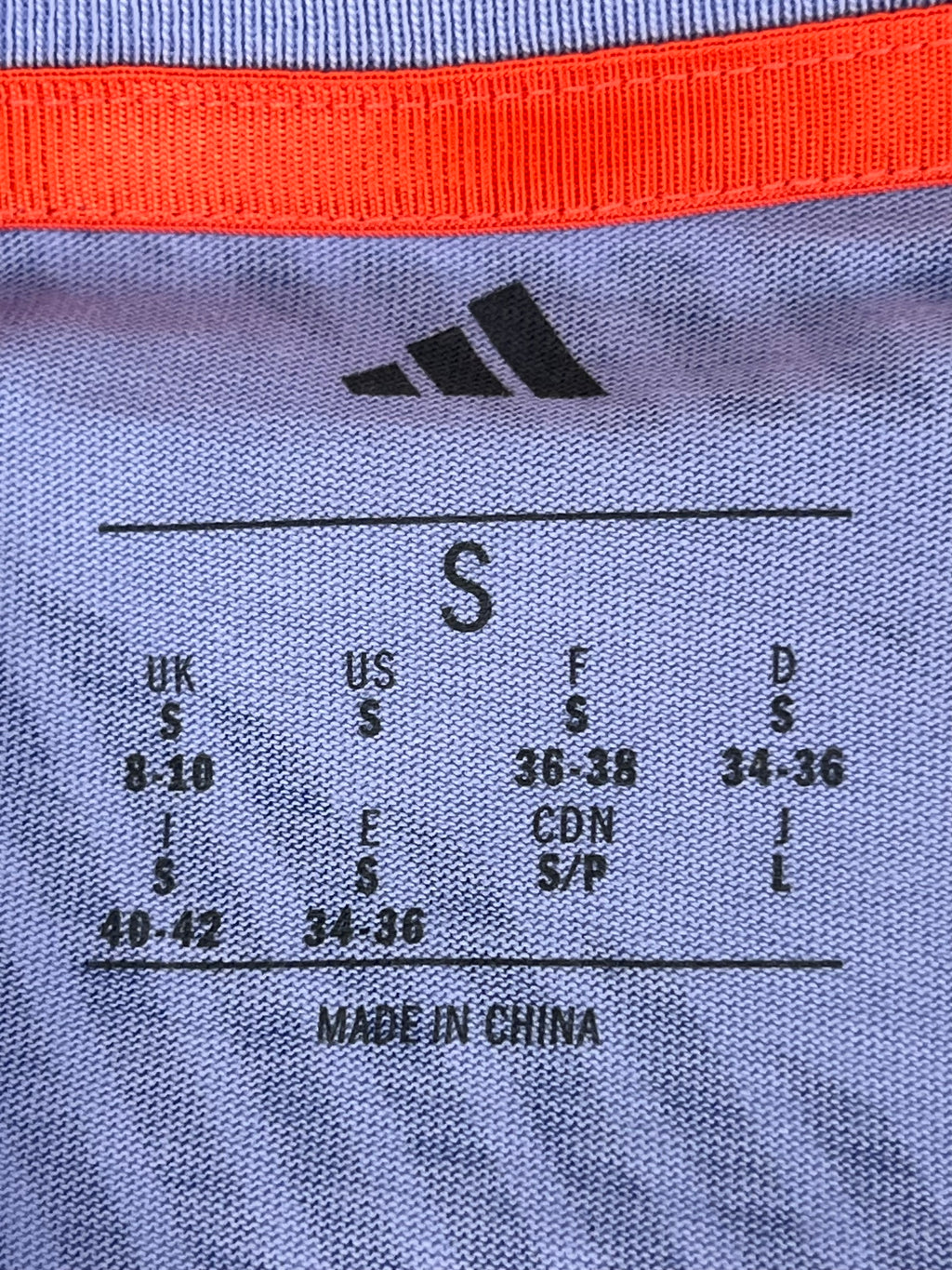 Close-up of Adidas size label inside women's Team GB patterned T-shirt, showing small size (UK 8-10)