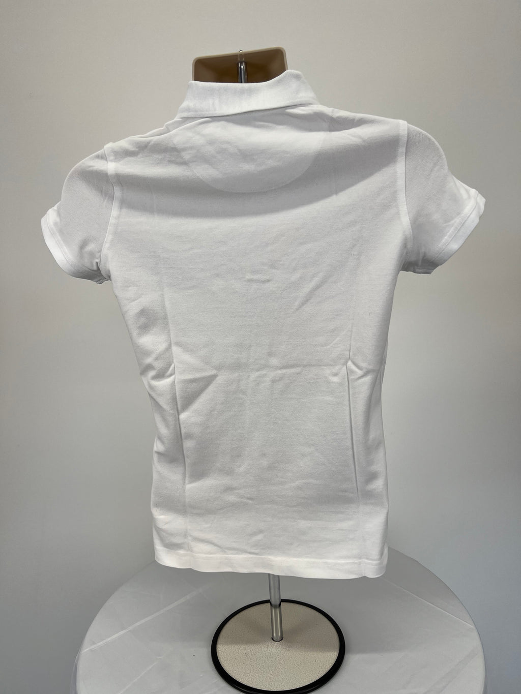 Back view of women’s white polo shirt showing plain design and collar