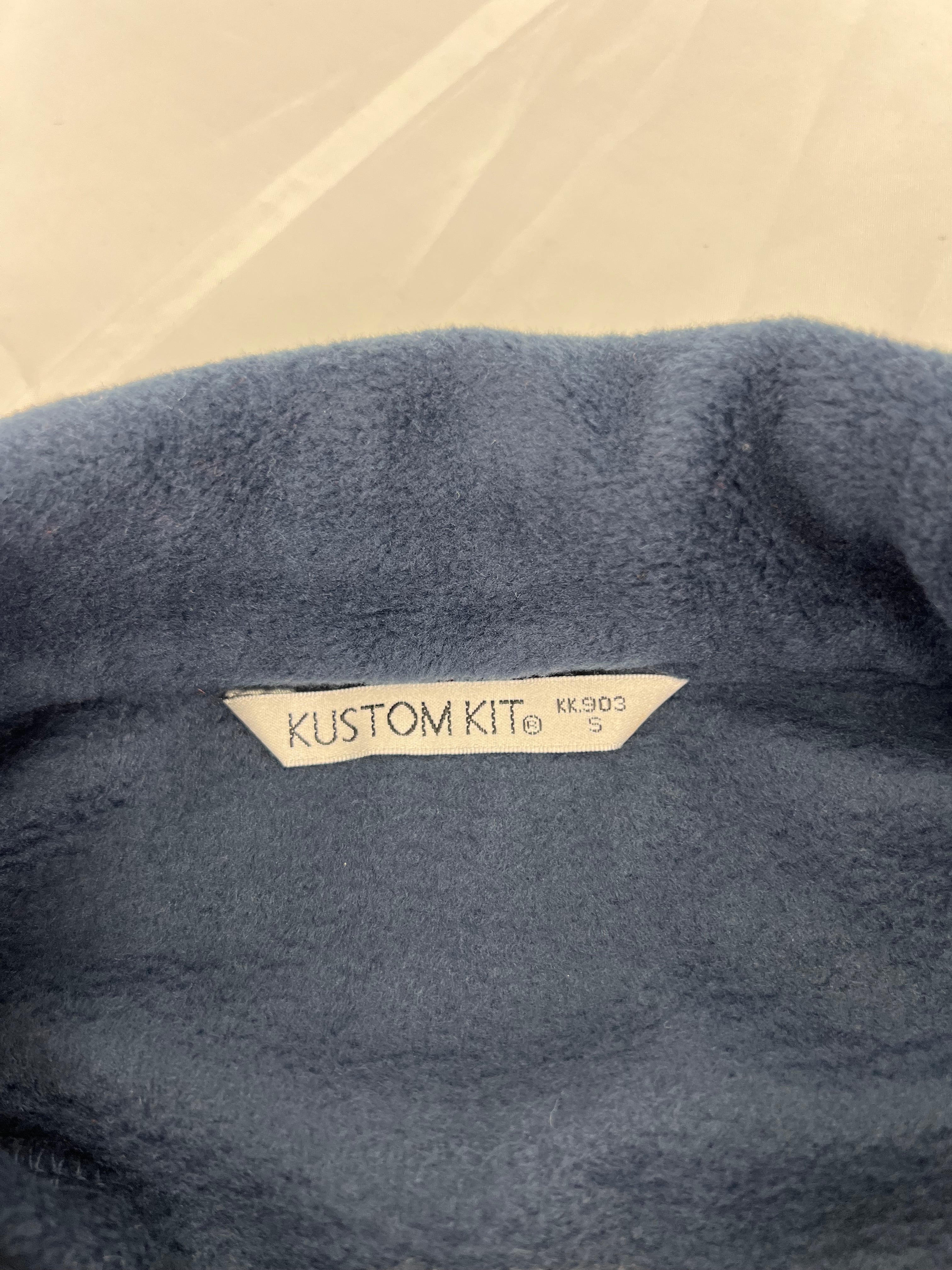 Close-up of inside label on men's navy fleece jacket reading KUSTOM KIT with size S