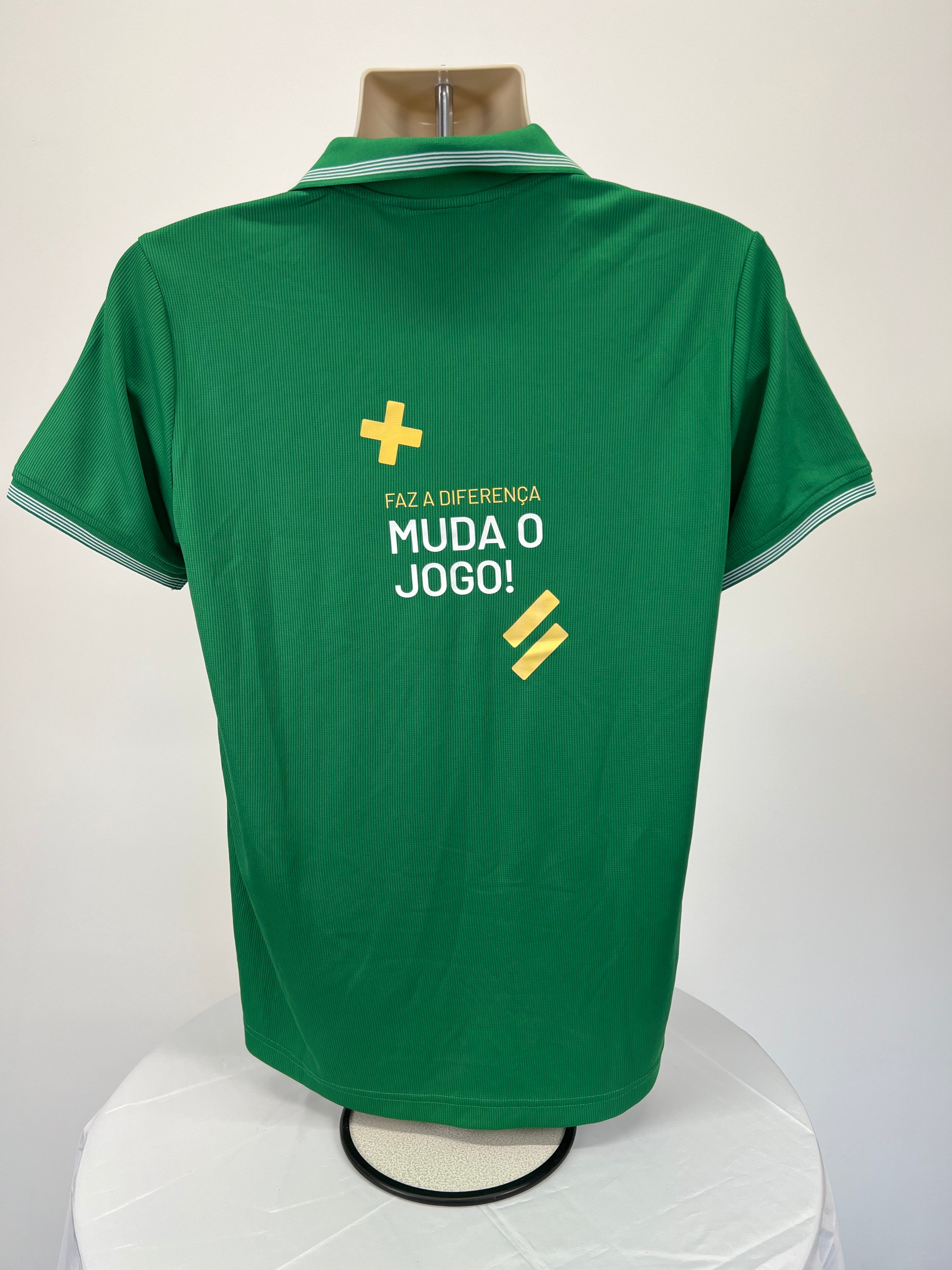 Back view of green men's polo showing Portuguese motivational text and symbols in yellow and white print