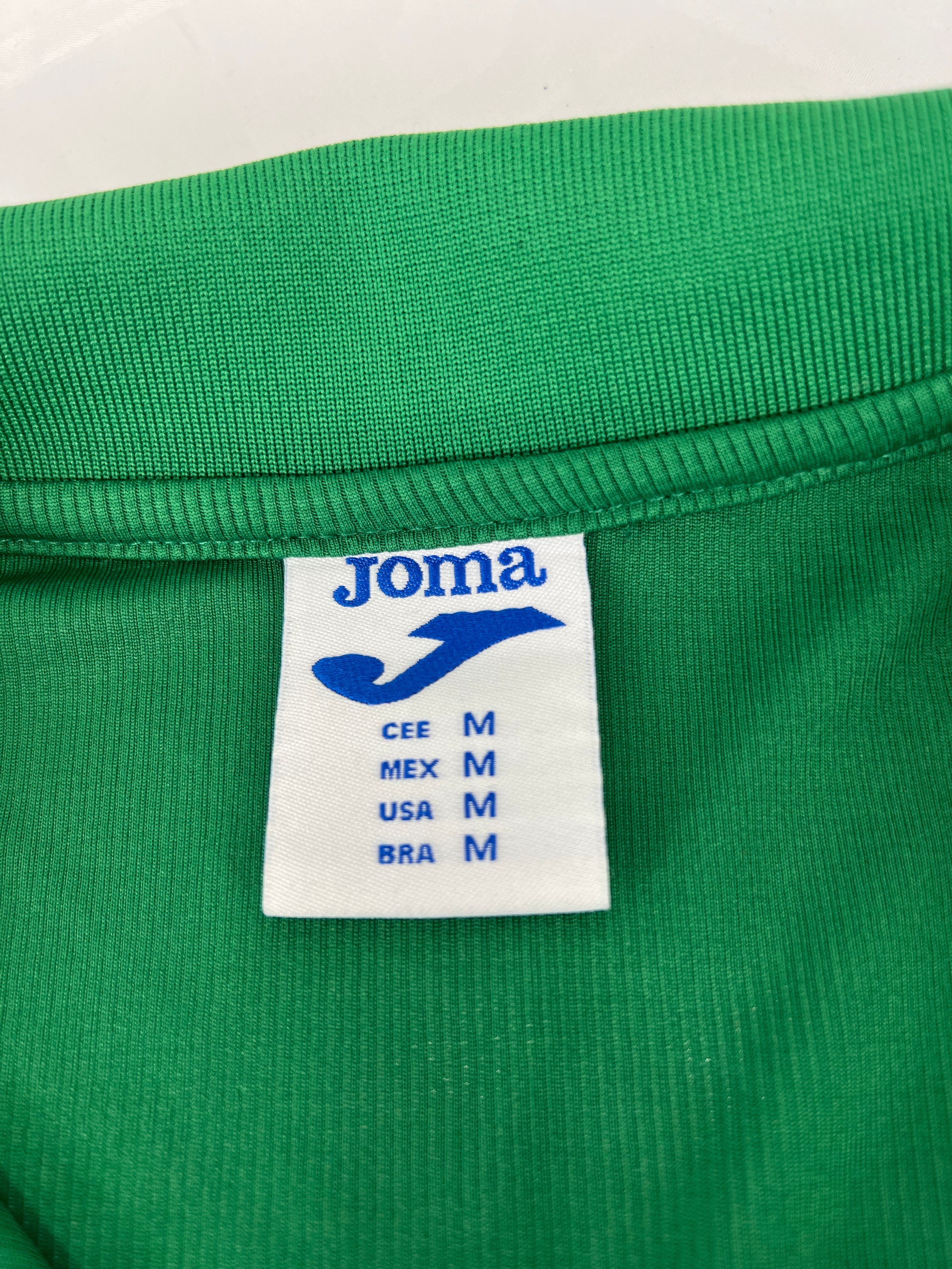 Close-up of Joma brand label inside the collar showing size medium in various country standards