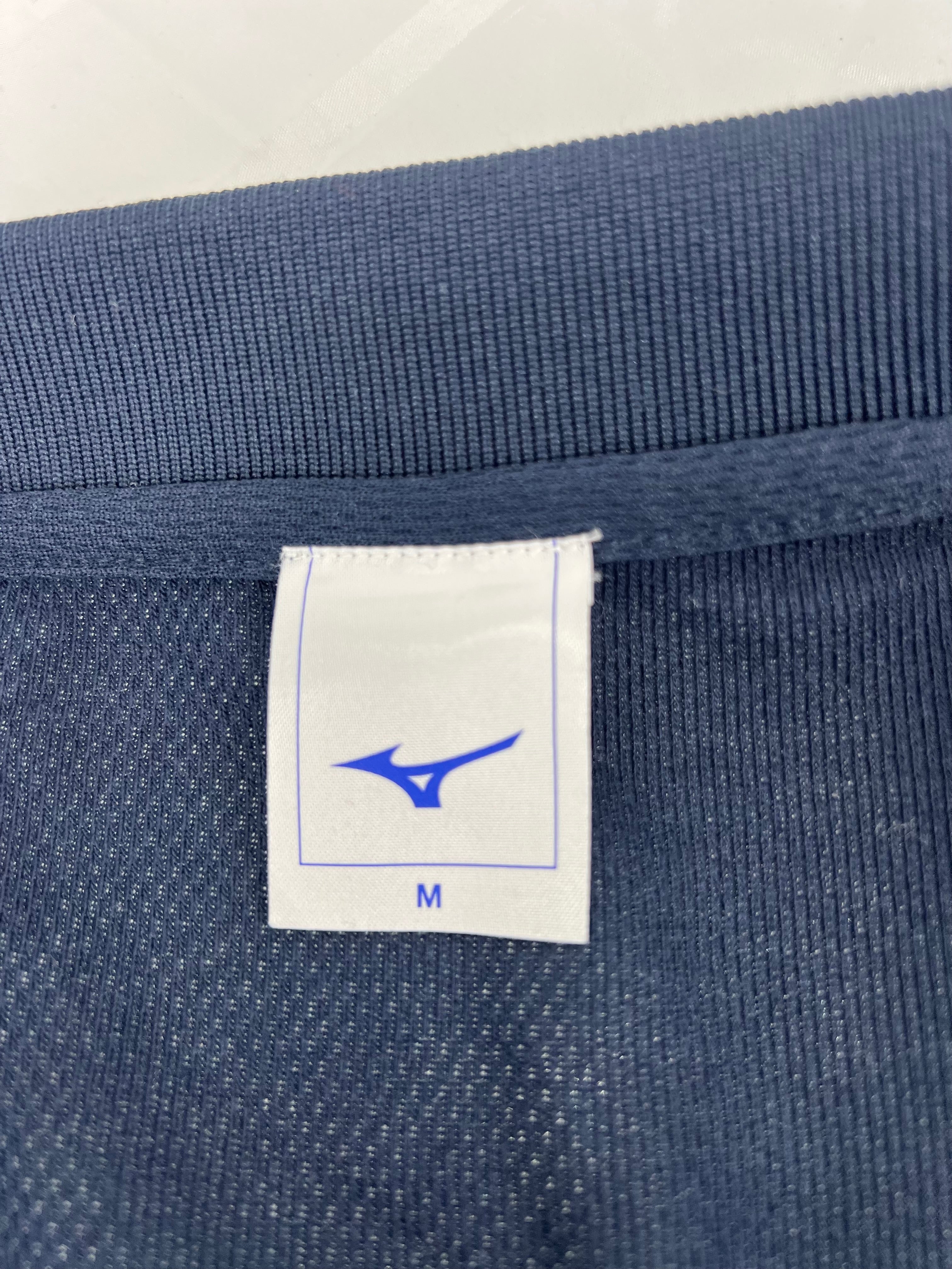 Close-up of Jara polo shirt size tag inside collar