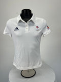 Front view of white women’s Adidas Team GB polo top with logos and button collar