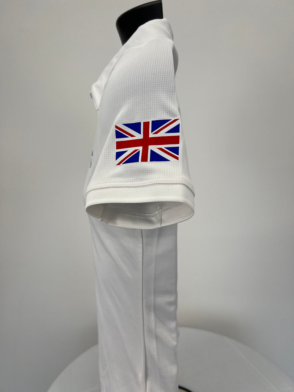 Side view showing Union Jack flag detail on sleeve of white polo top