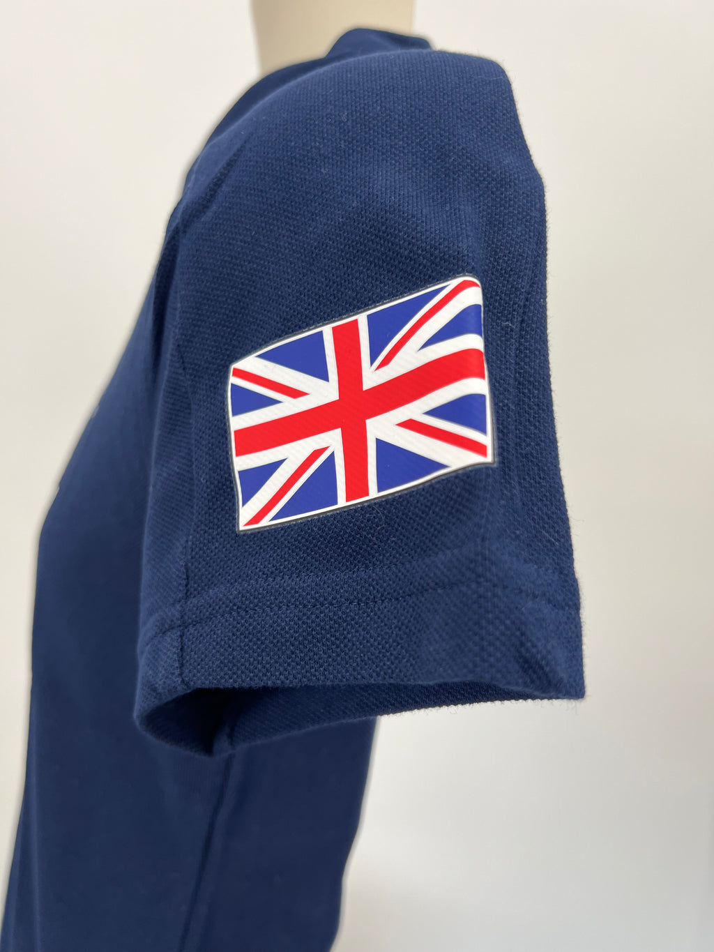 Close-up on the left sleeve featuring British Union Jack flag patch on navy fabric