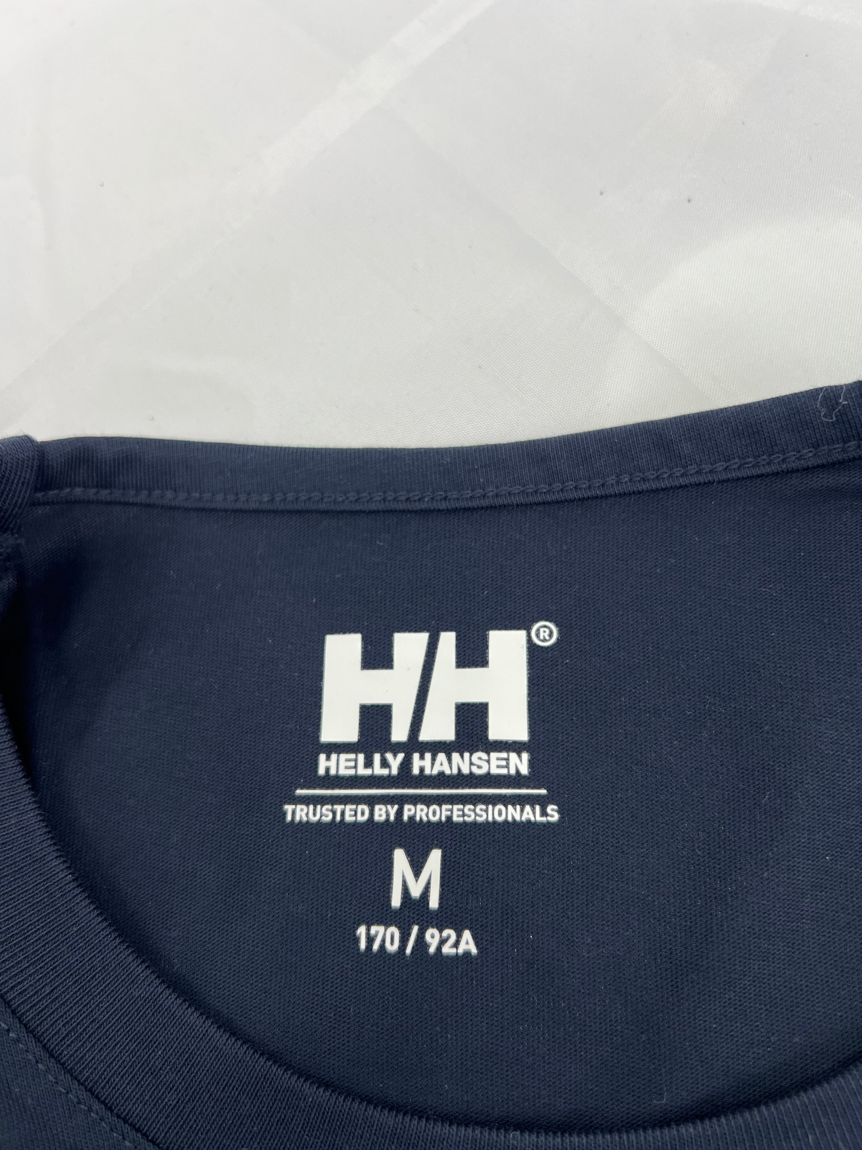 Close-up of inside neck label of Helly Hansen t-shirt with size medium and Trusted by Professionals tagline