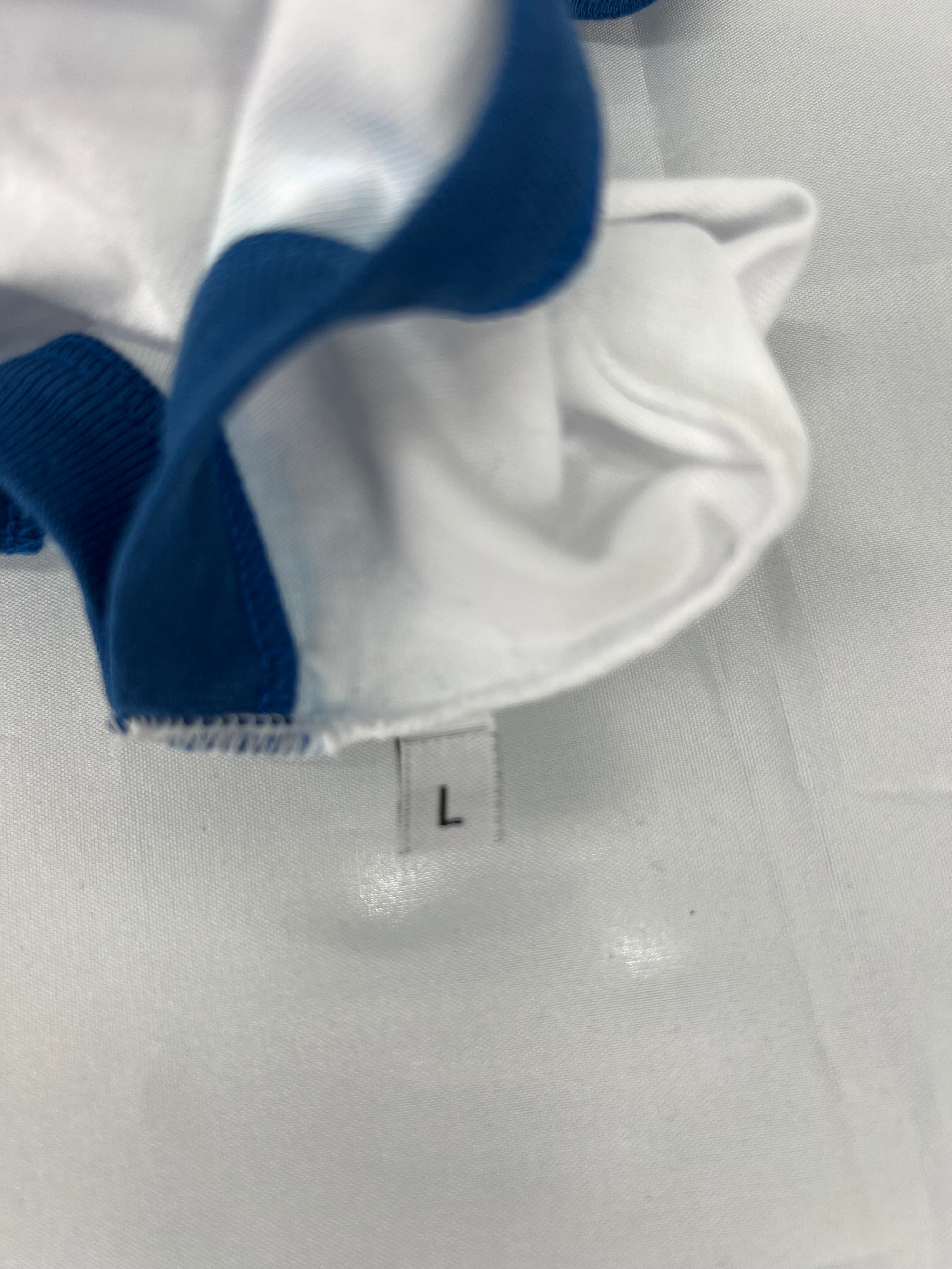 Close-up of inside tag showing size L on white cotton fabric with blue trim detail