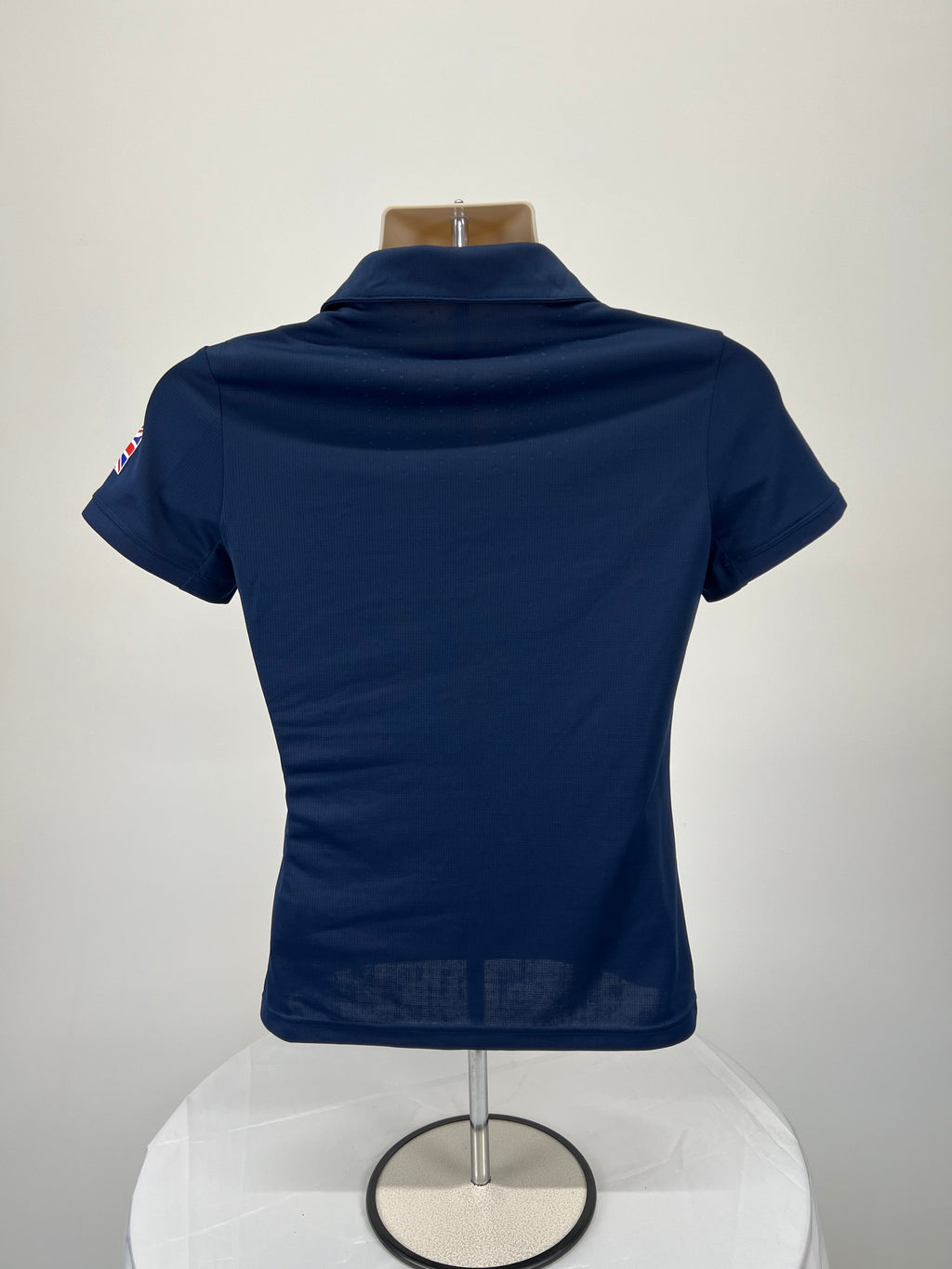 Back view of women's Adidas Team GB navy blue polo shirt showing plain design and collar