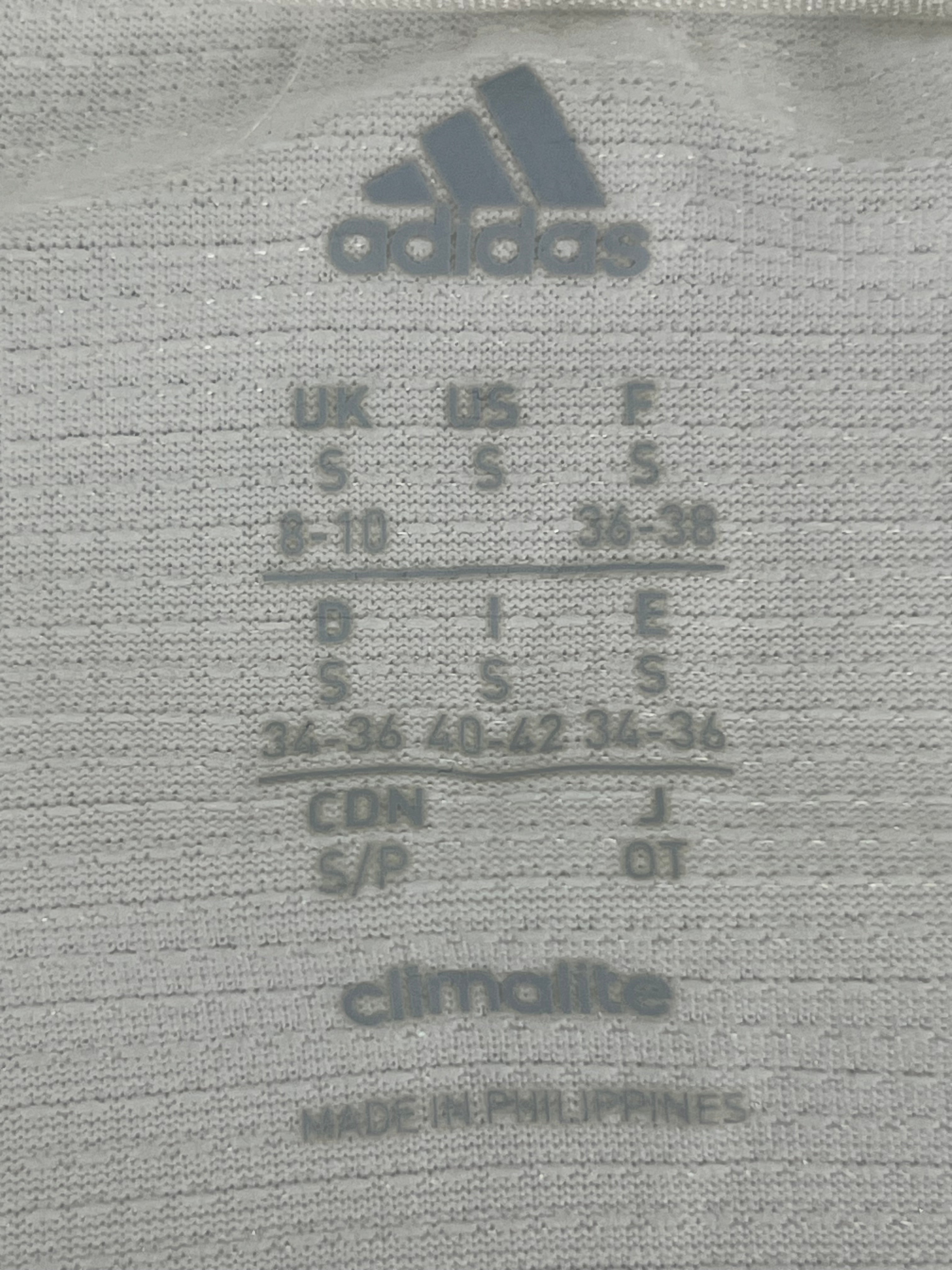 Close-up of adidas size label and Climalite fabric detail on women's long sleeve top