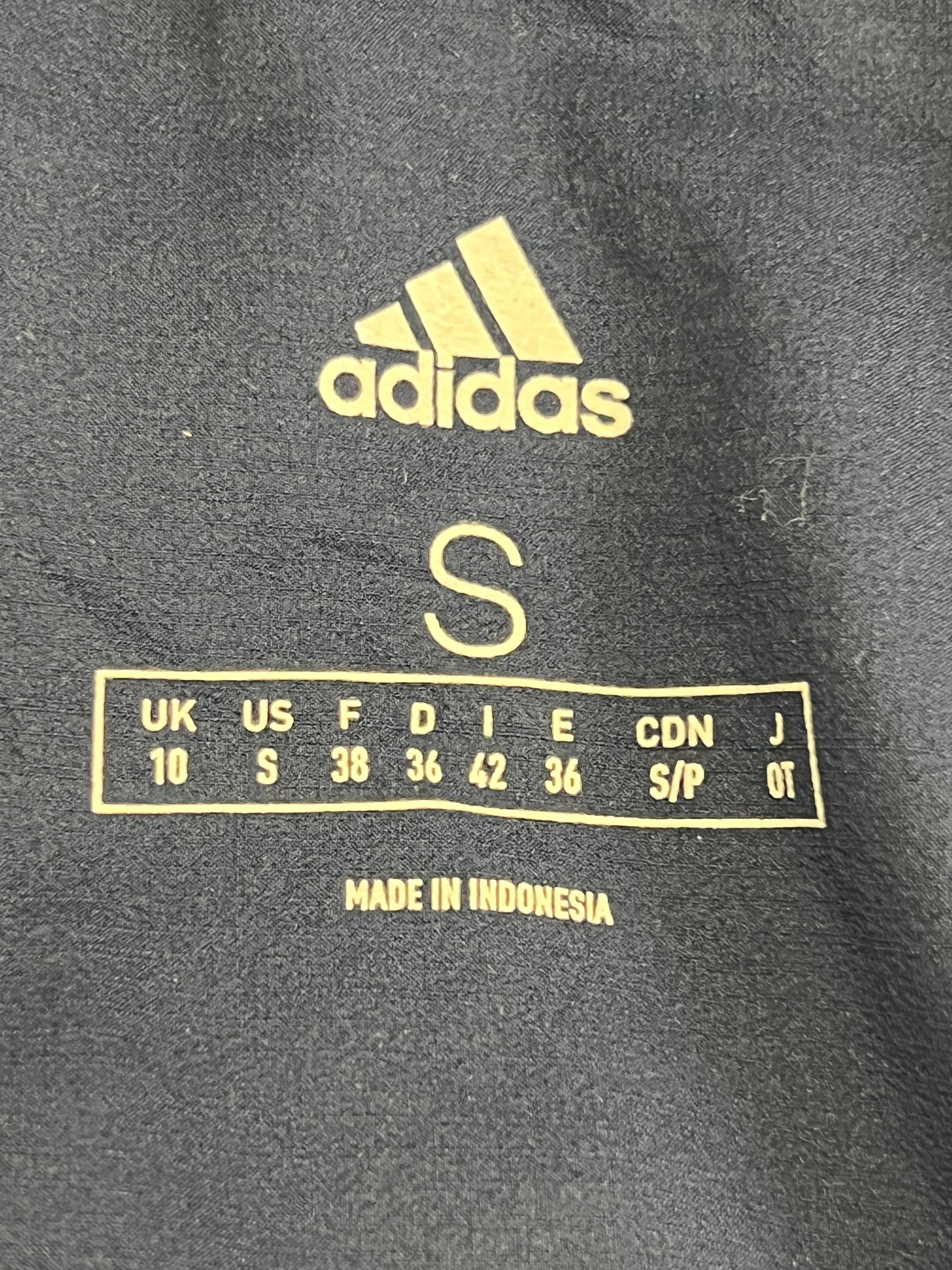 Close-up of Adidas brand label inside the women's gilet showing size Small and made in Indonesia
