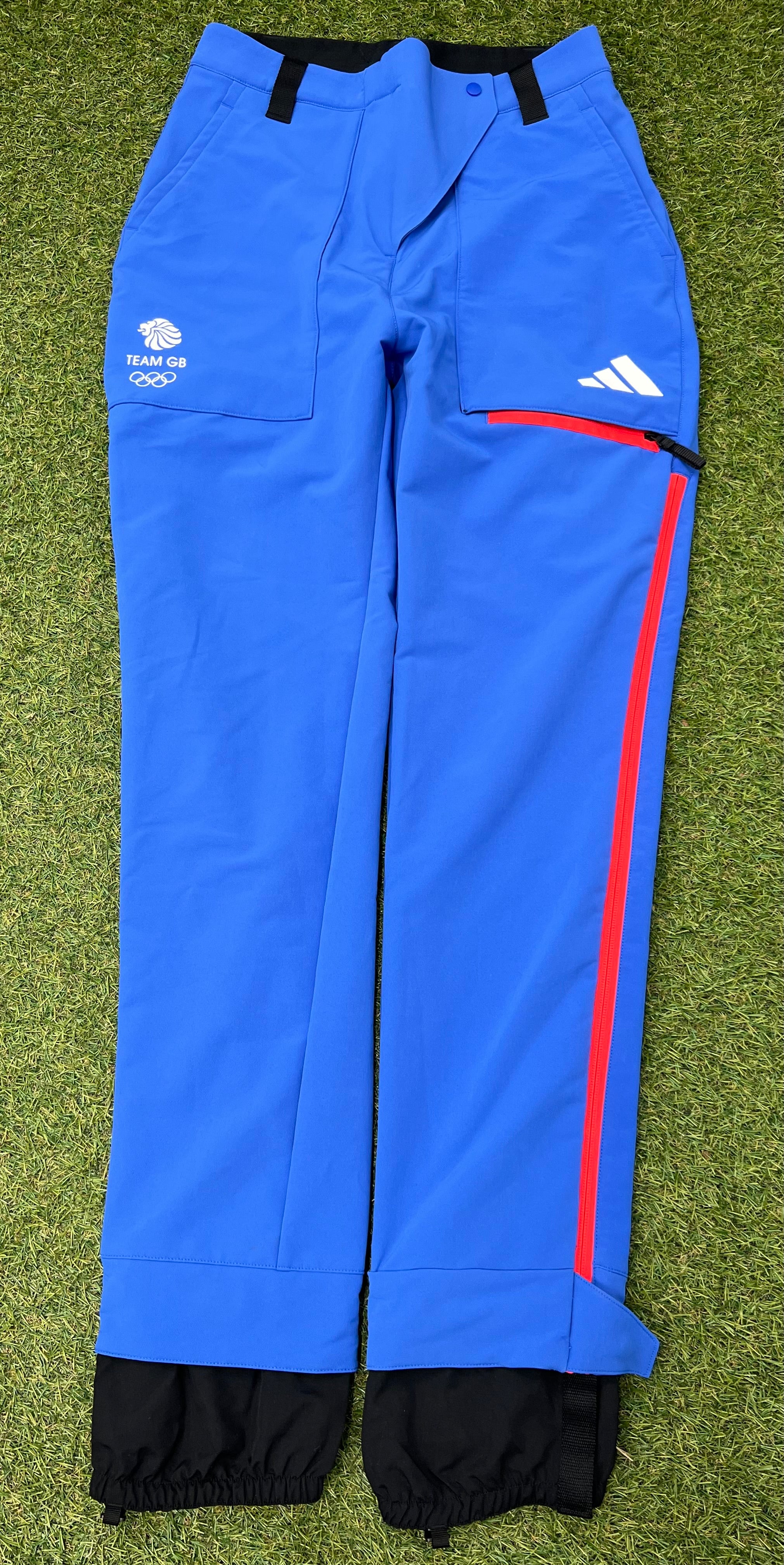 Front view of adidas Team GB women's blue ski trousers with red side zippers and pockets
