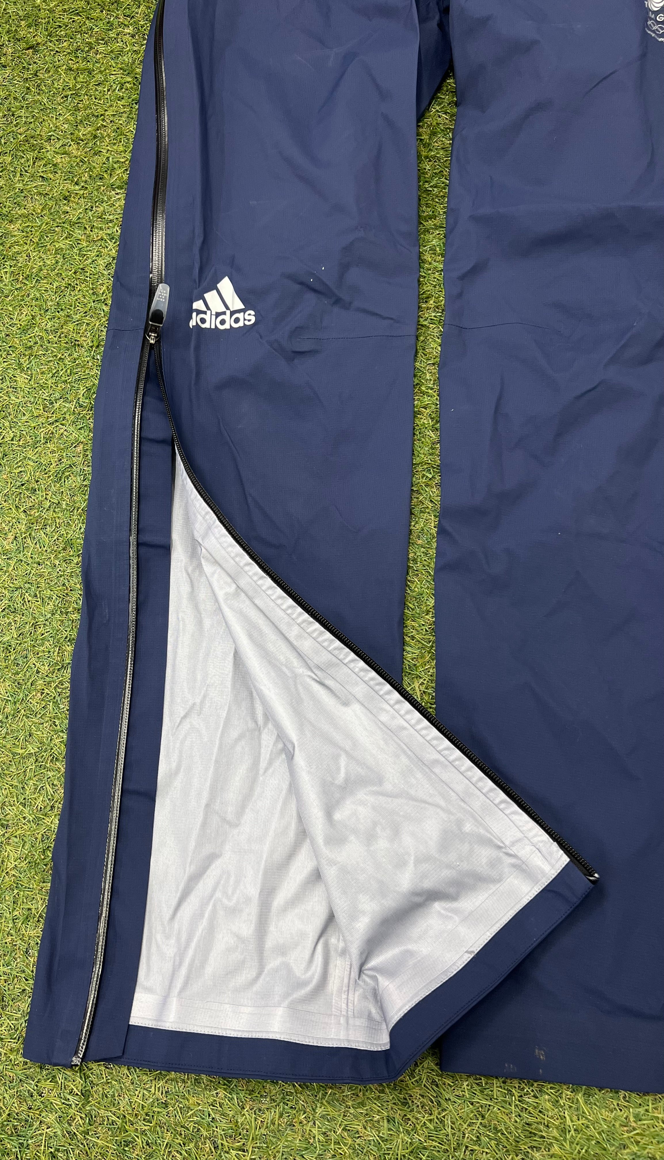 Close up of navy waterproof trousers unzipped to reveal inner lining and taped seams