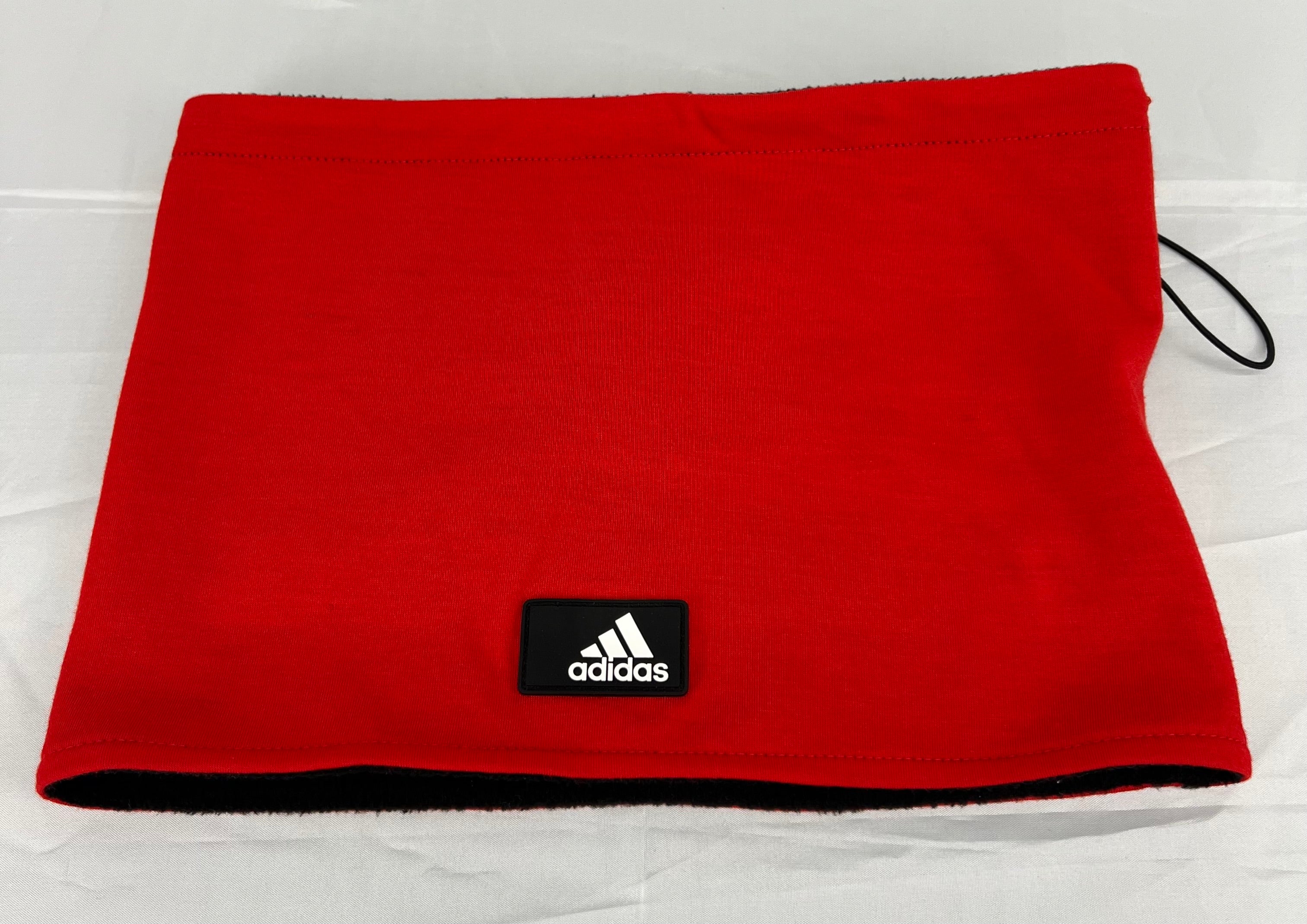 Red Adidas neck warmer with black fleece lining and Adidas logo patch on front