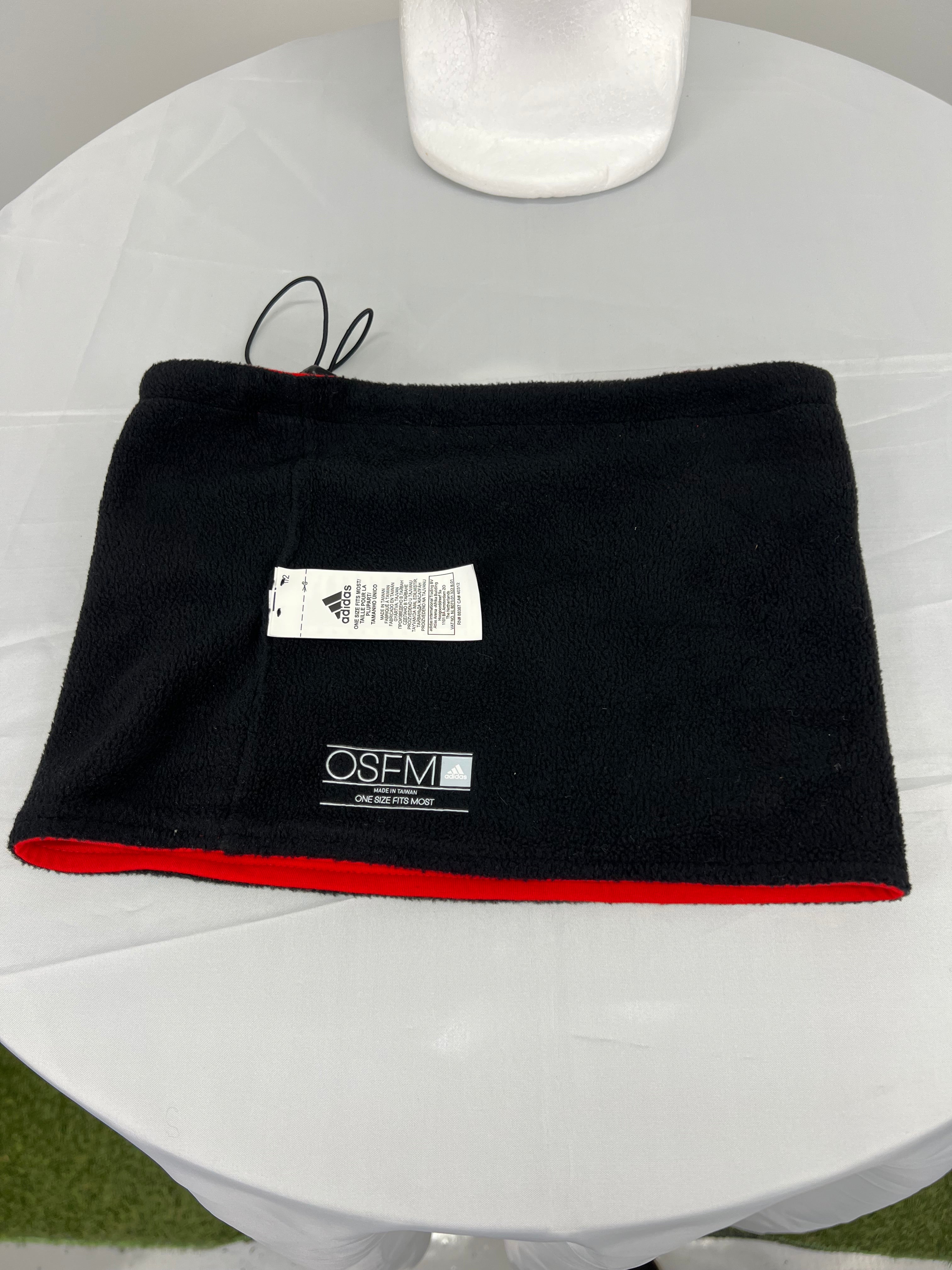 Red neck warmer with Team GB logo and Adidas patch on flat surface