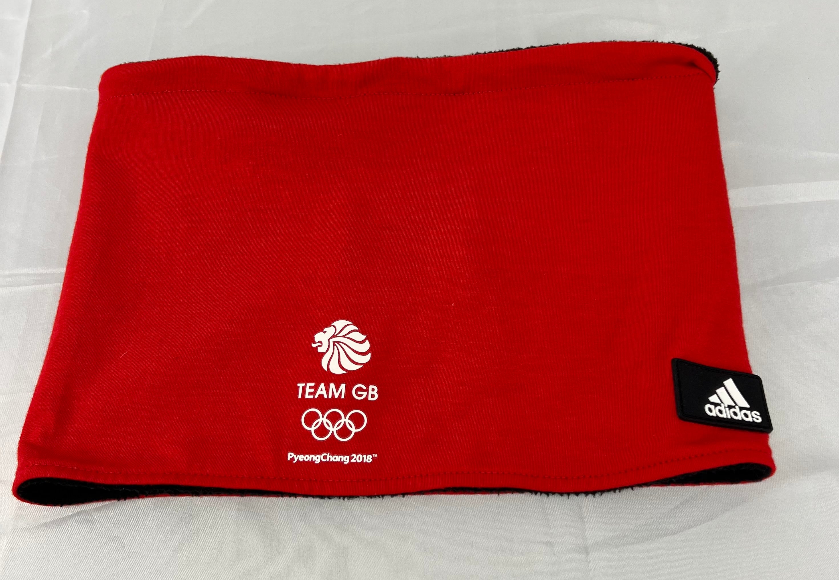 Red Team GB neck warmer lying flat with ParalympicsGB embroidered logo on reverse