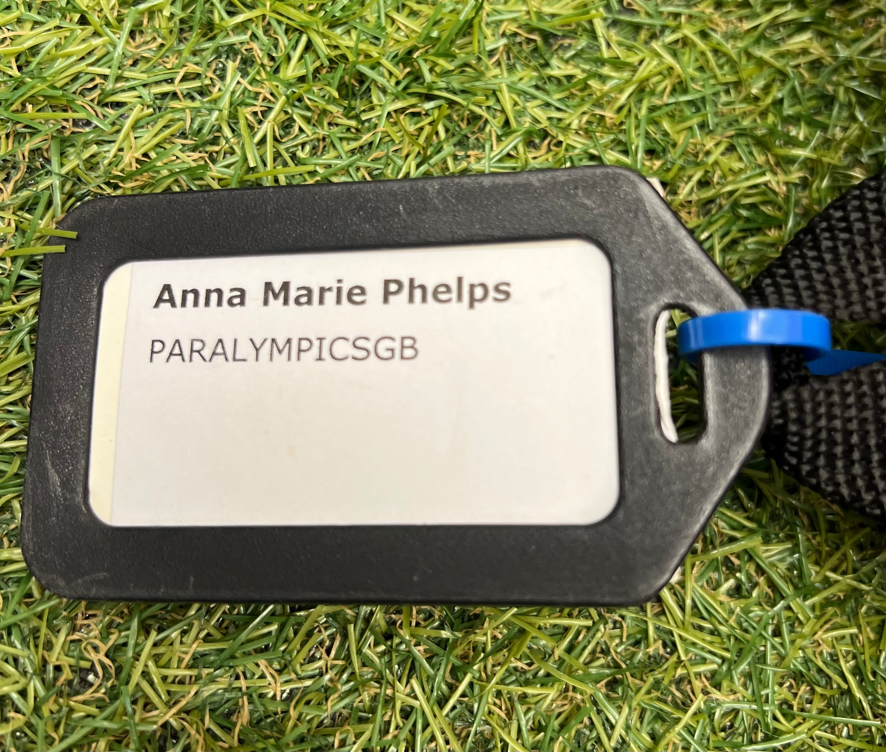 Name tag labeled 'Anna Marie Phelps PARALYMPICSGb' attached to the bag