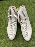 Top view of classic white women's figure skates with laces tied on grass background