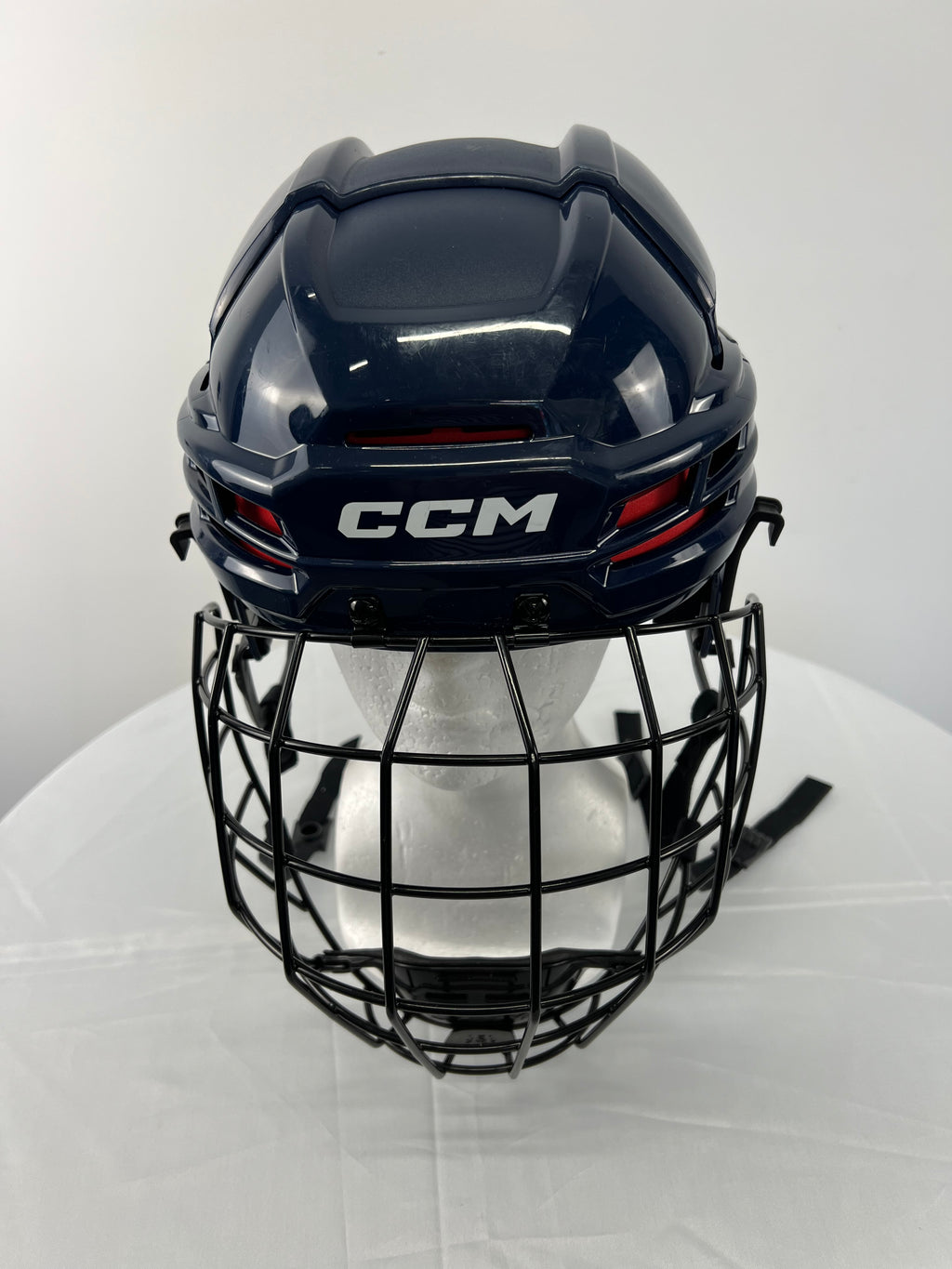 Front view of navy CCM Tacks 70 youth hockey helmet with black face guard