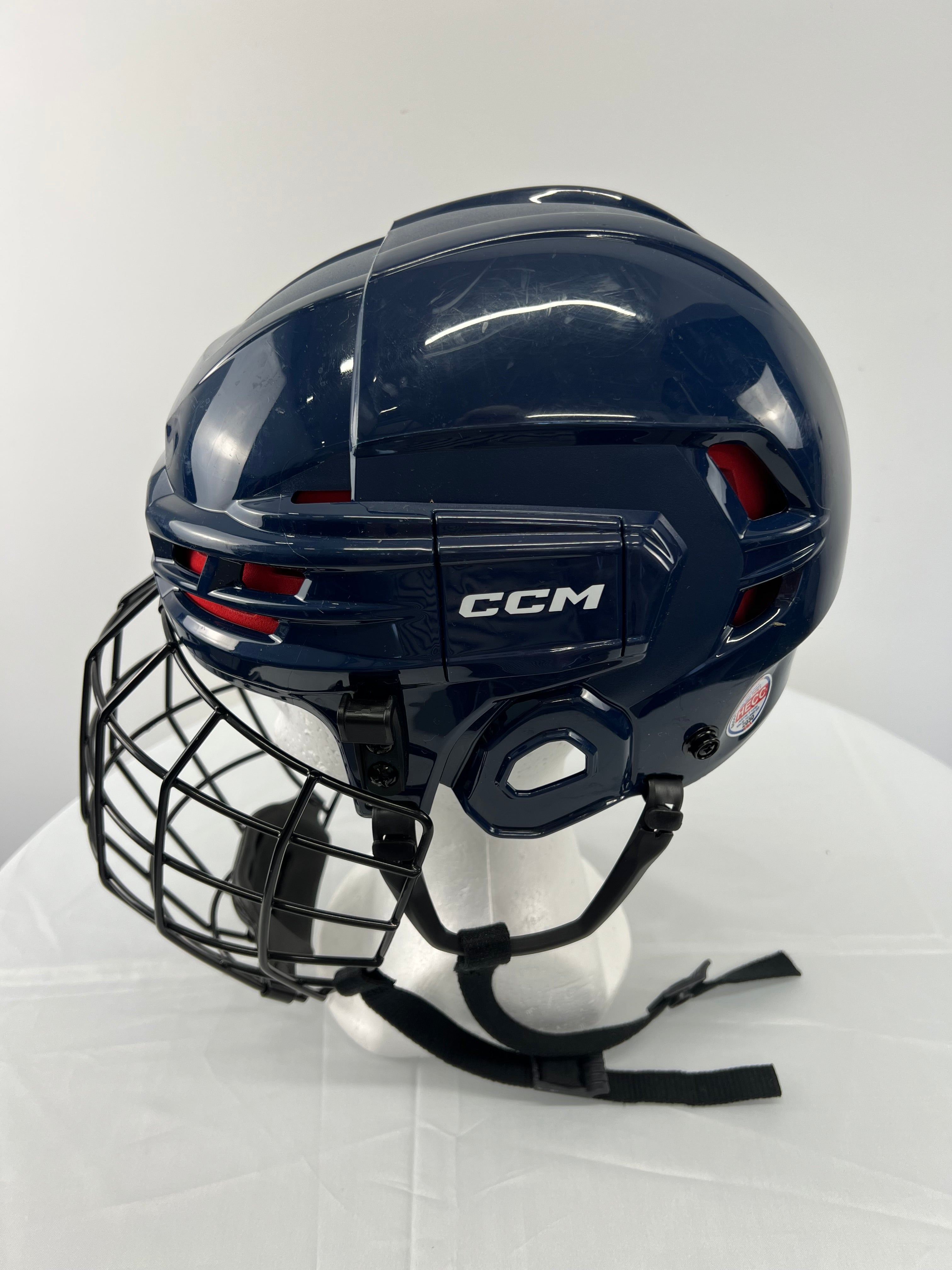 Side view showing CCM branding and vents on navy hockey helmet