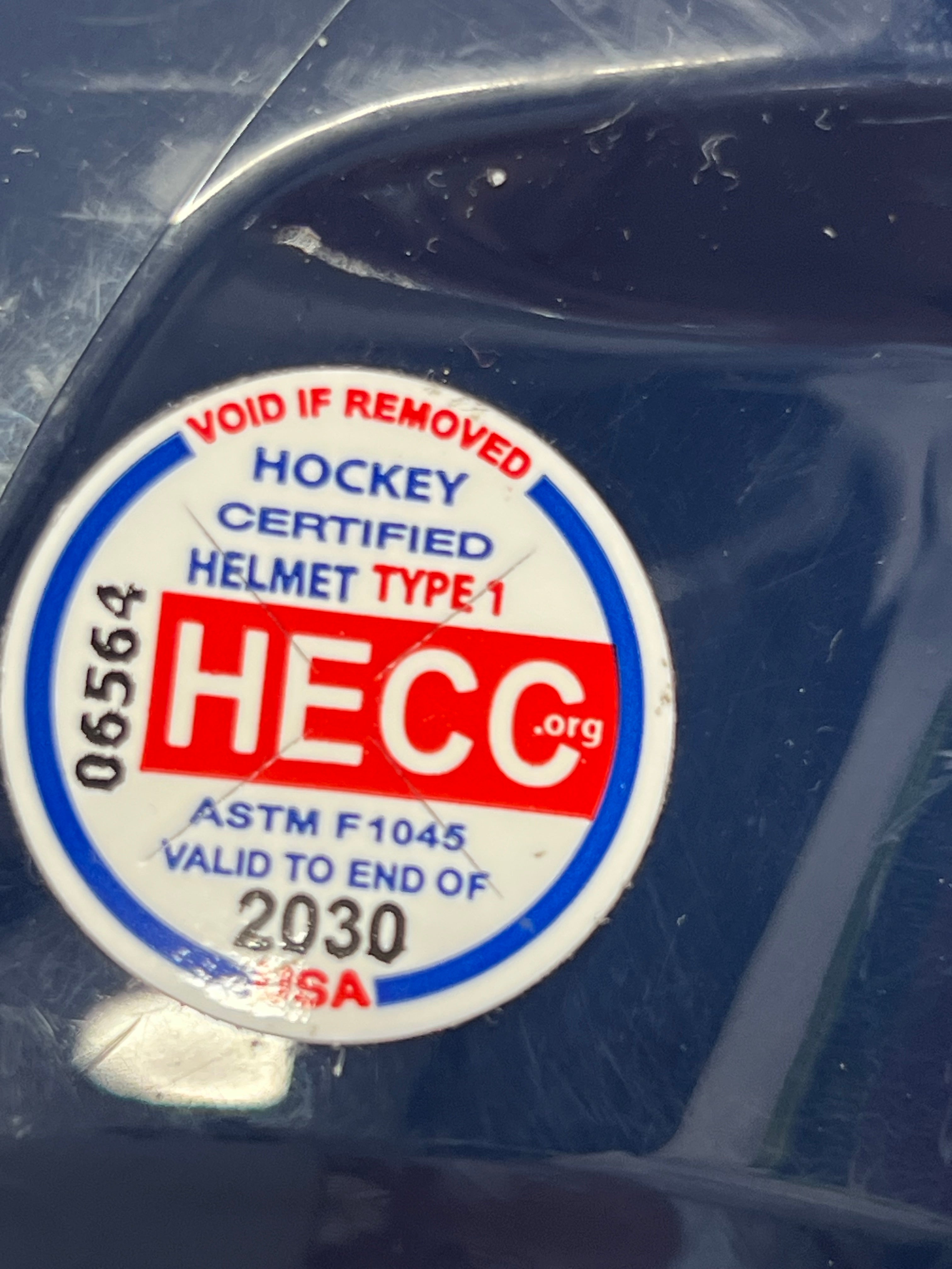 Close-up of CSA certification sticker for 2023 on navy hockey helmet