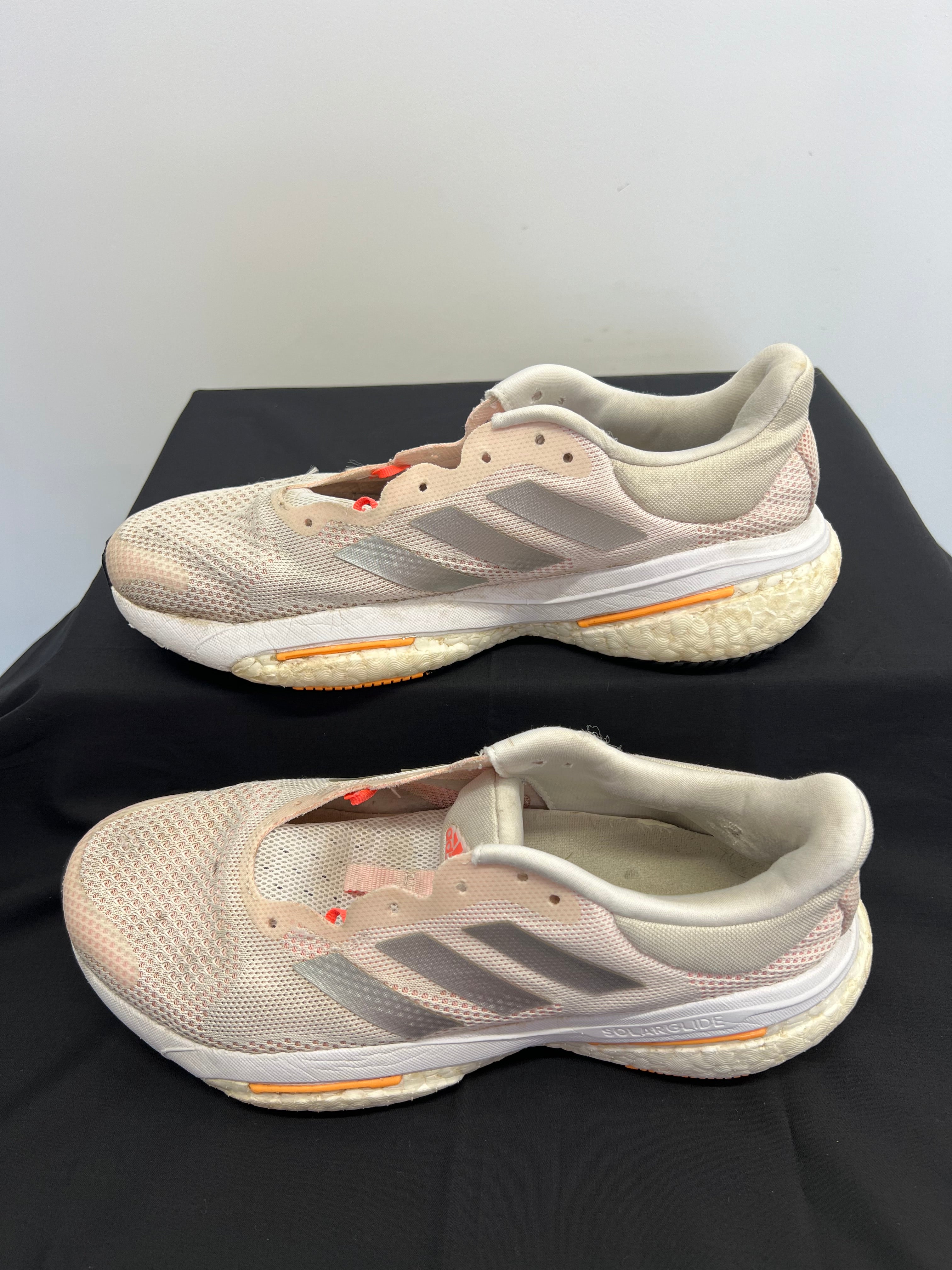 Opposite side view of beige adidas Solar Glide running shoes with orange accents