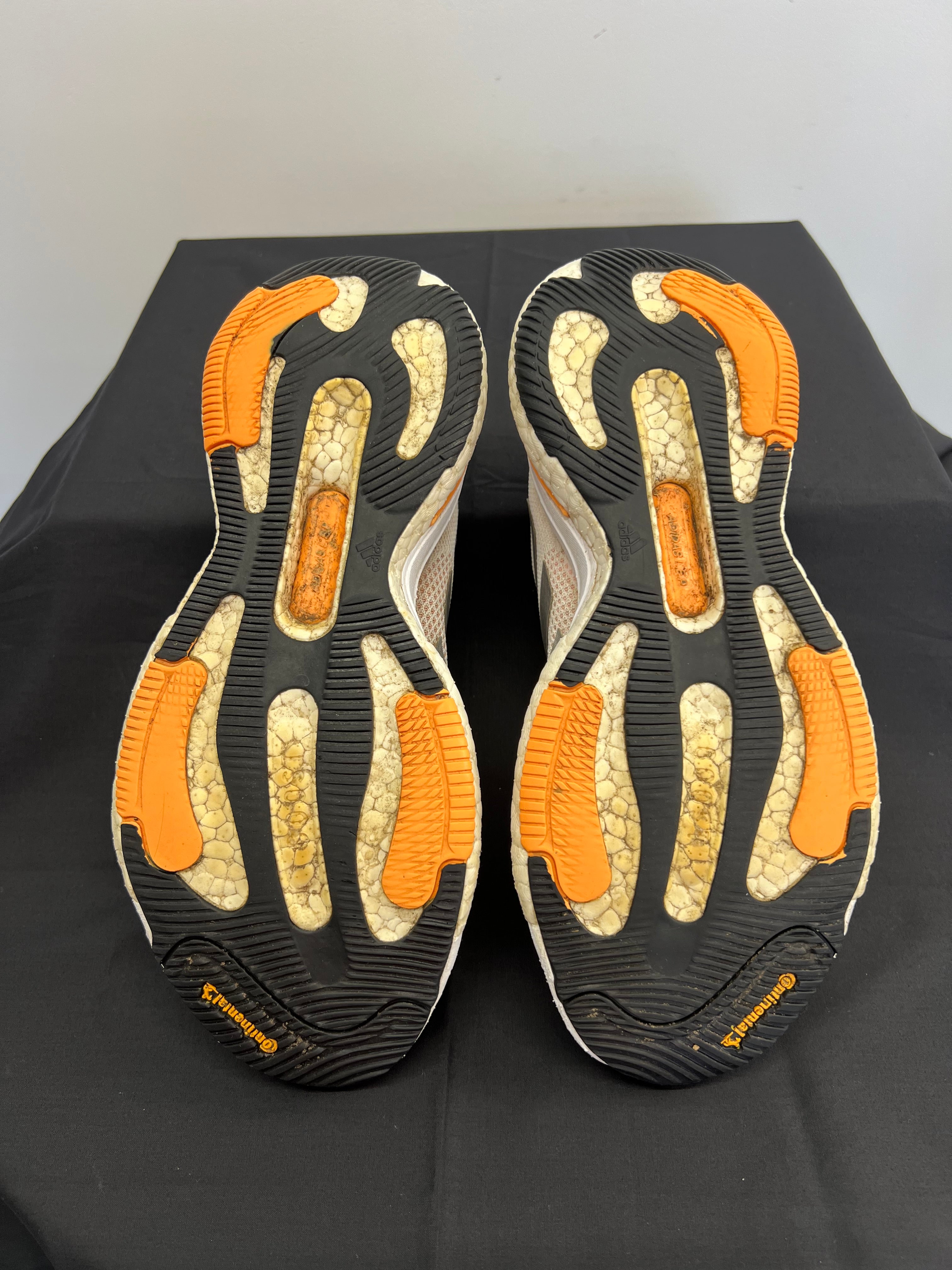 Soles of adidas Solar Glide shoes showing Continental rubber grip with orange inserts