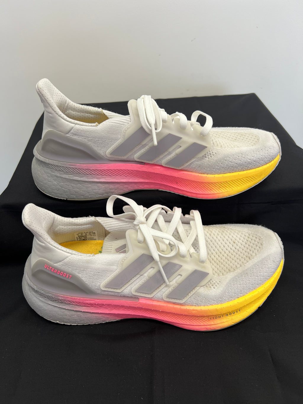Side view of adidas Ultra Boost trainers showing gradient midsole and three-stripe branding