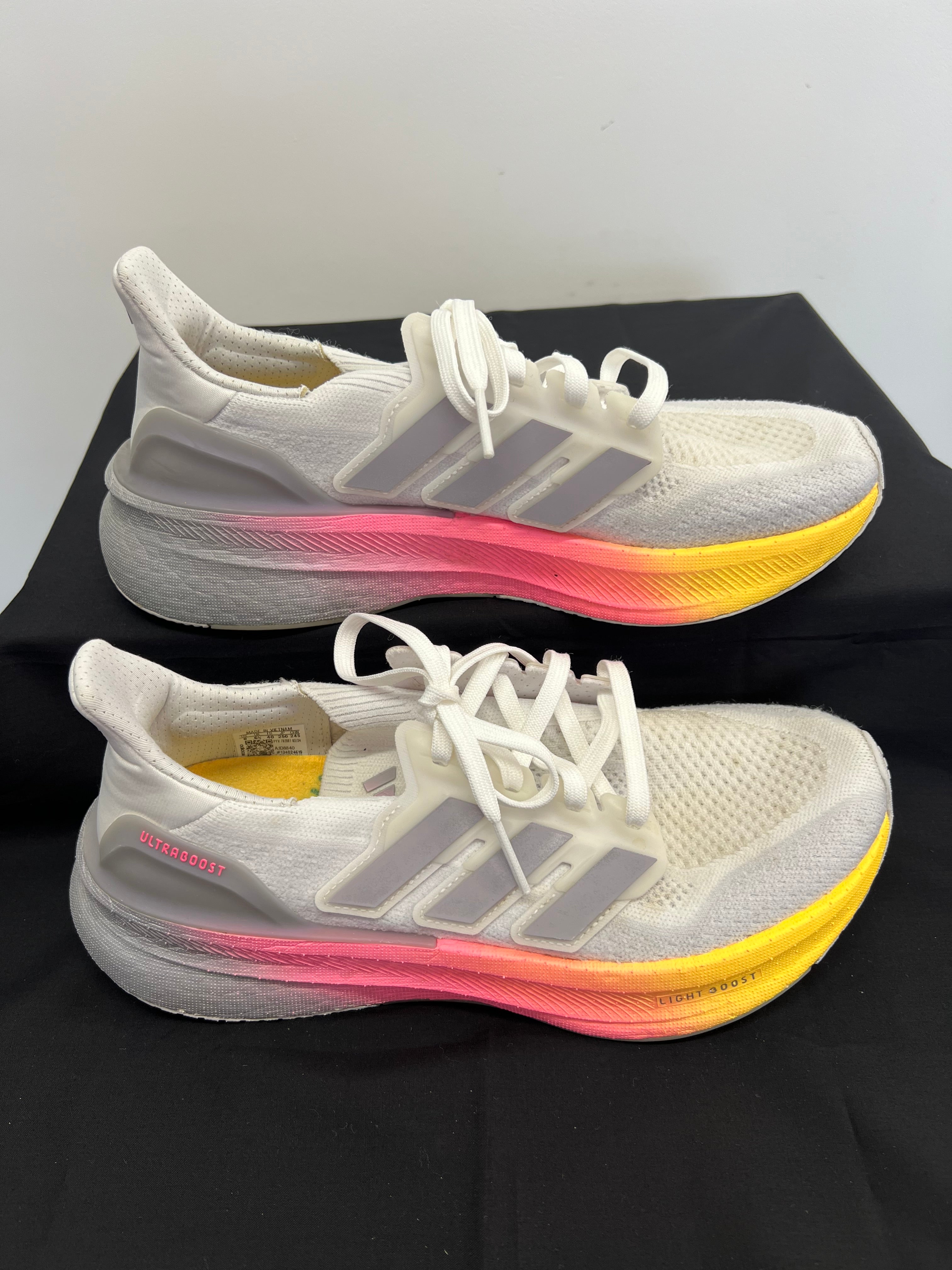 Side view of adidas Ultra Boost trainers showing gradient midsole and three-stripe branding