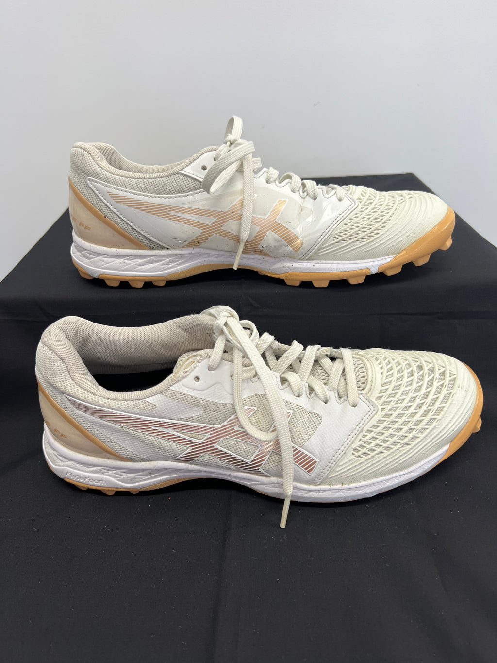 Side profile of Asics Field Ultimate FF hockey shoe with beige accent and Asics logo