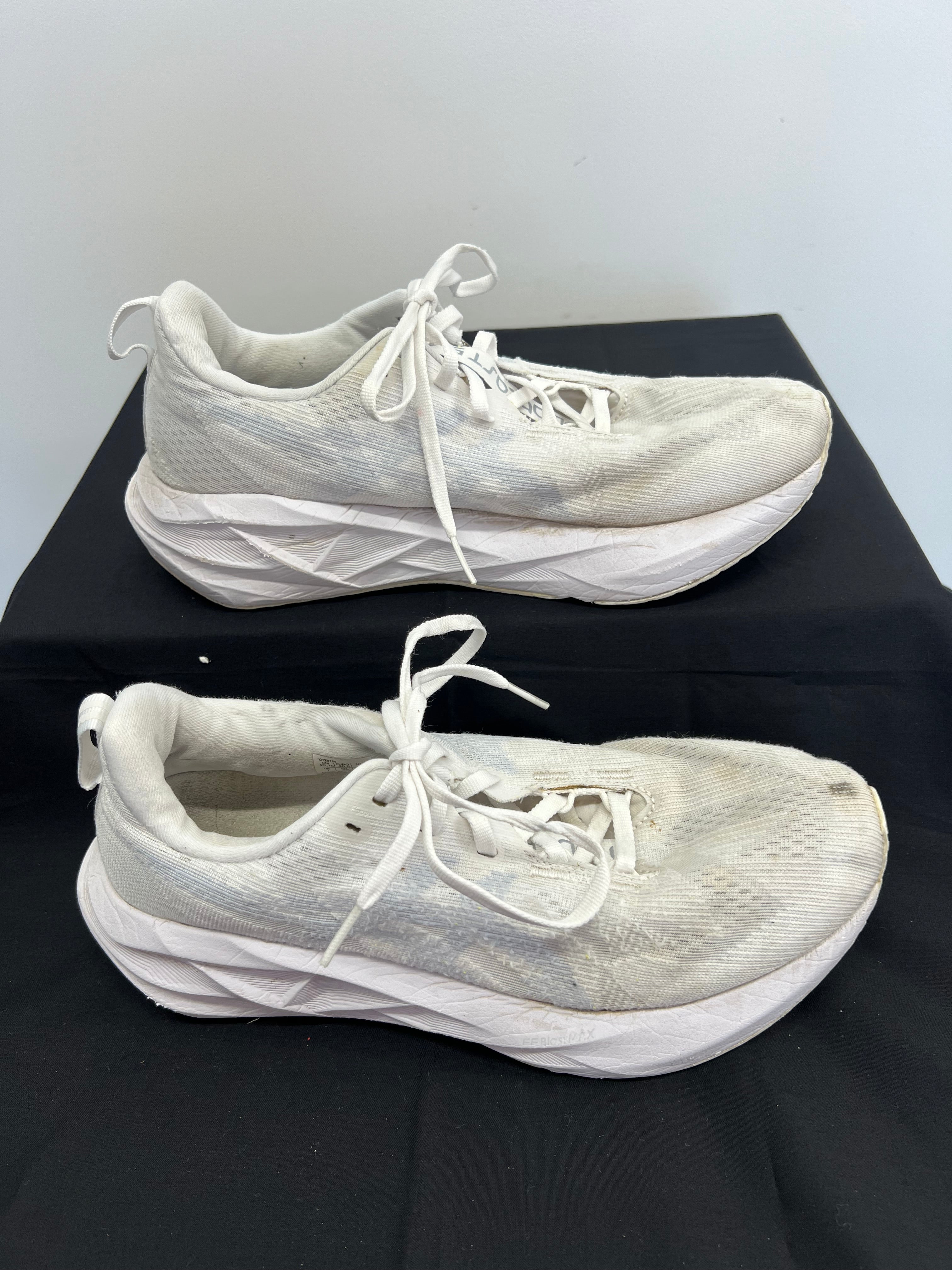 Side view of white Asics Novablast 5 trainers highlighting cushioned sole and mesh upper